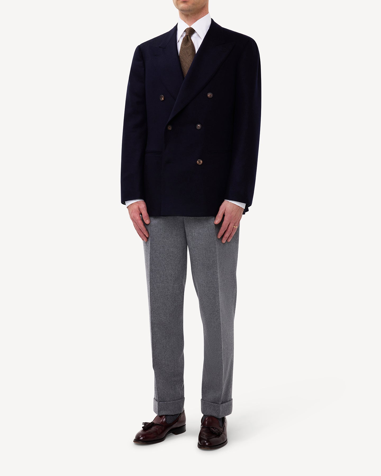 Man wearing navy flannel double breasted sport coat and light grey flannel trousers
