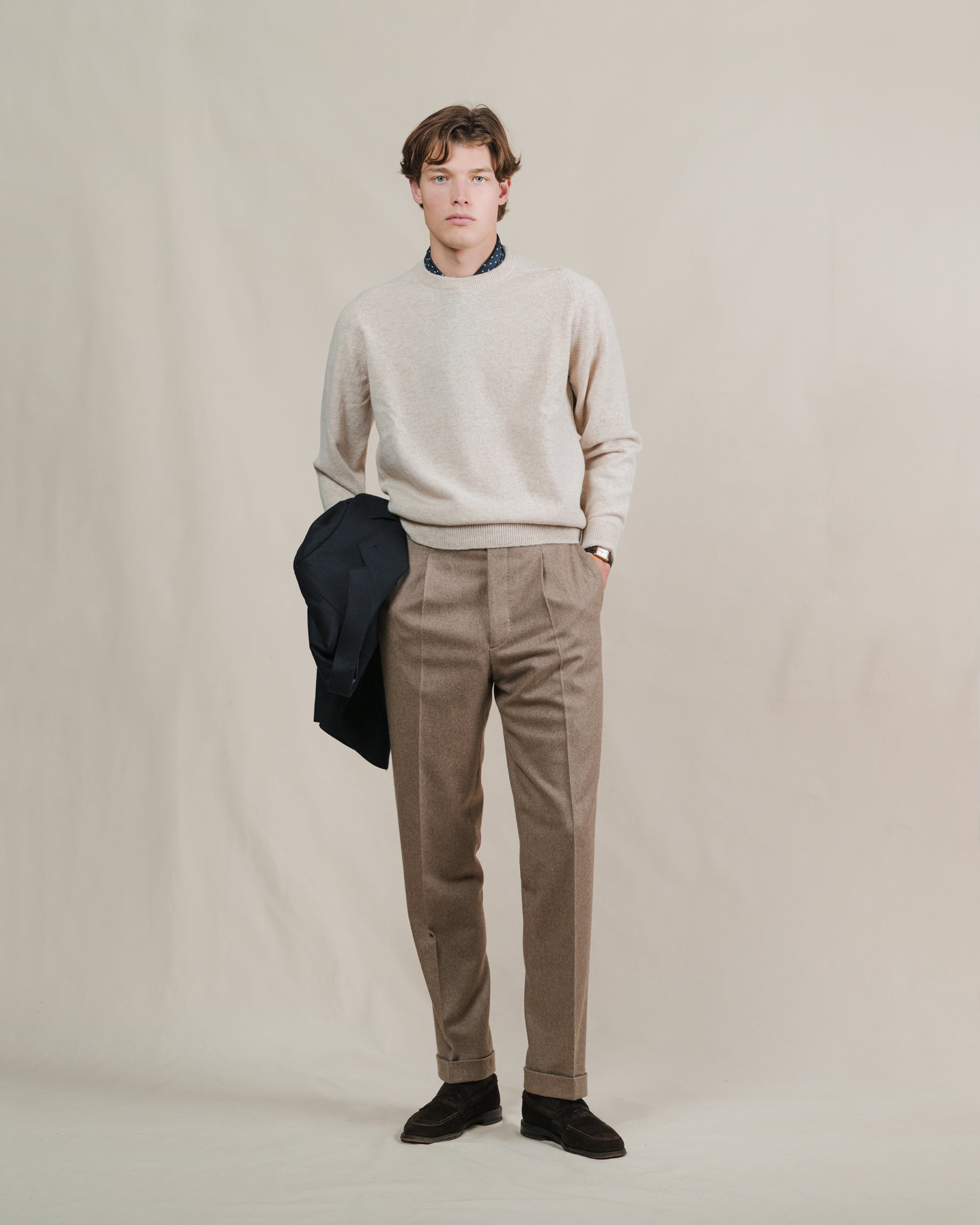 Man wearing fawn flannel trousers with an oatmeal crewneck