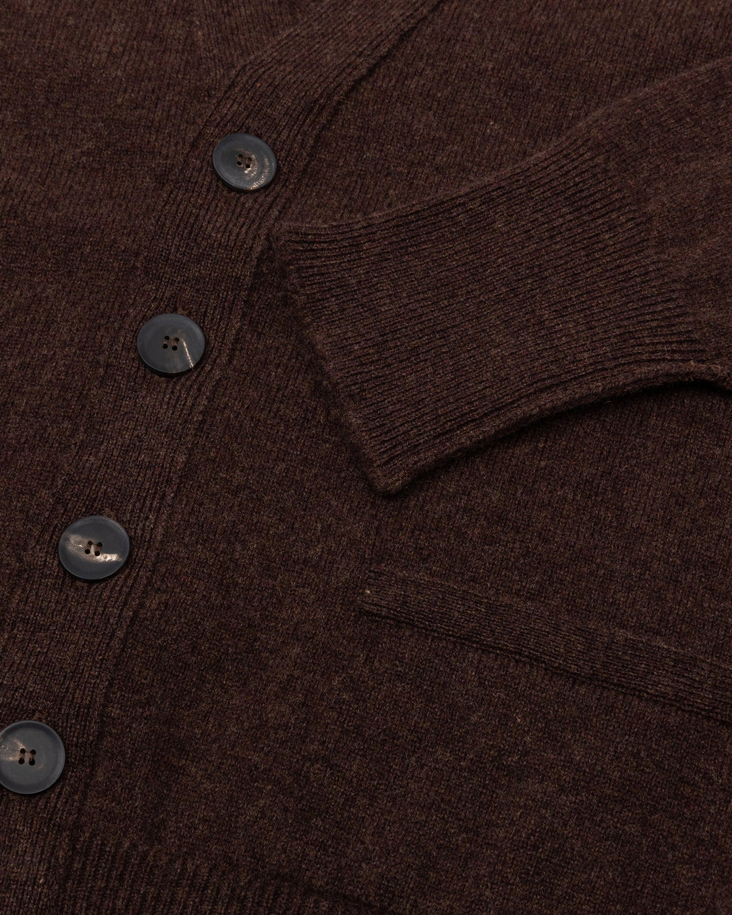 A dark brown lambswool cardigan with horn buttons and front pockets