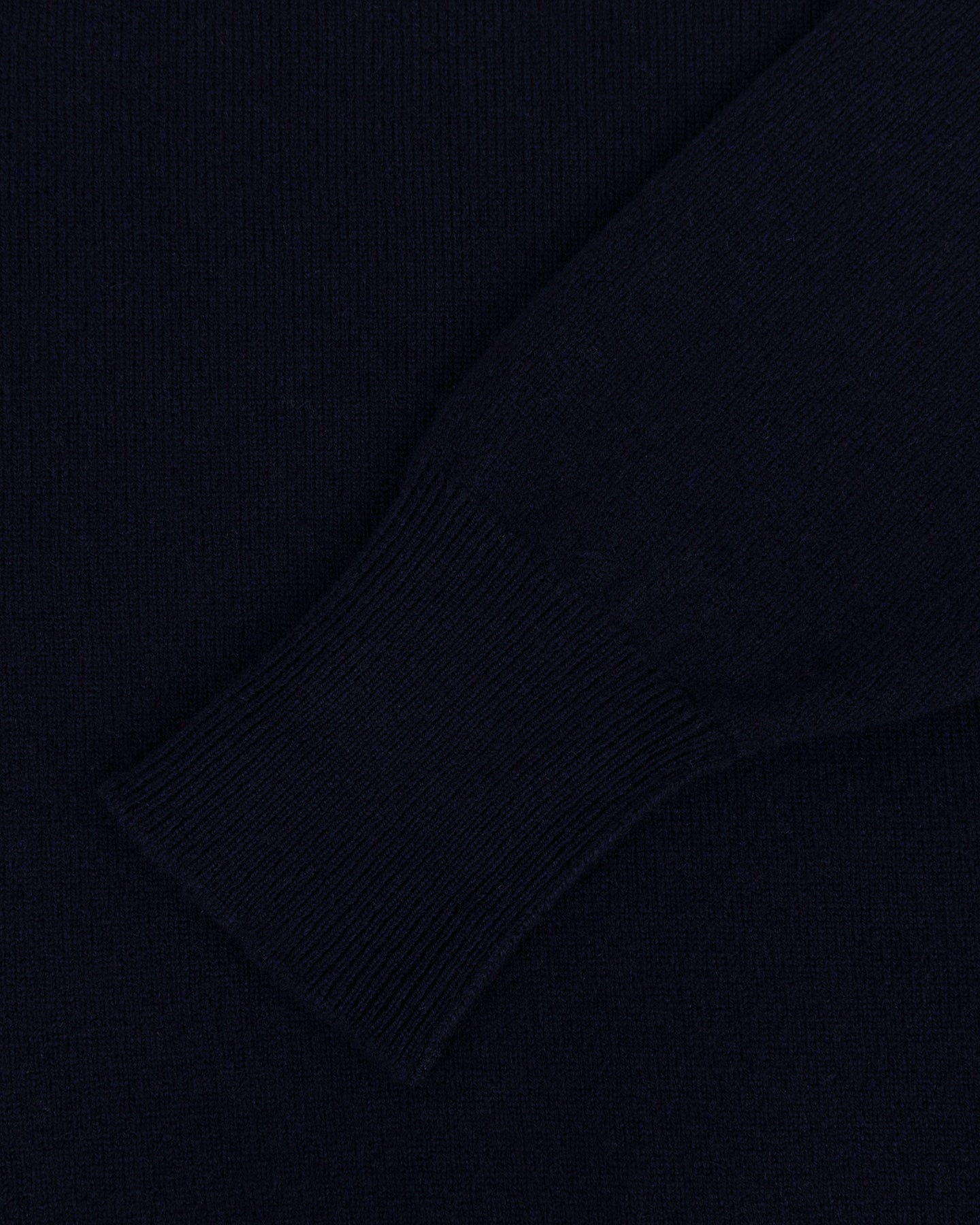 A navy lambswool sweater with turnback cuffs