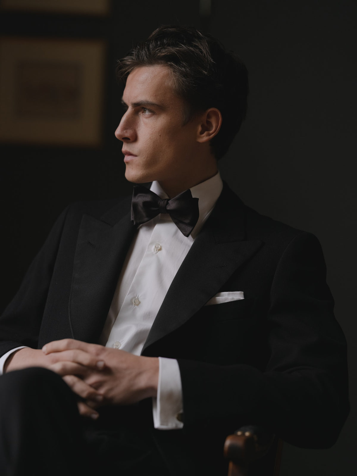 Man wearing a single breasted peak label tuxedo with a white shirt and black bow tie