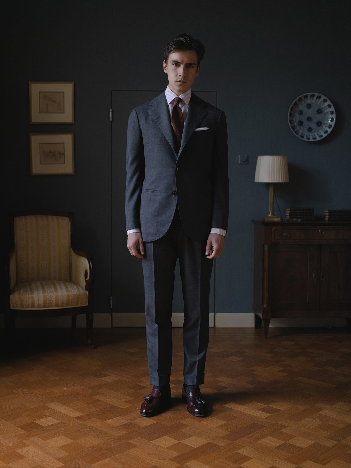 Man wearing a mid grey sharkskin suit, pink bengal stripe spread collar shirt and red pattern ancient madder tie