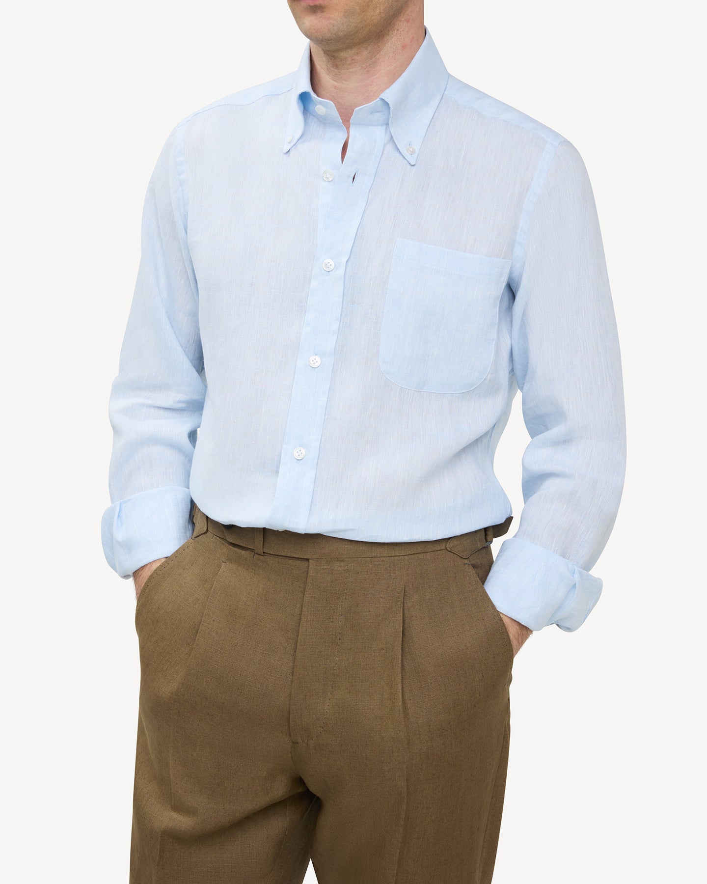 Man wearing light blue linen shirt and olive brown linen trousers
