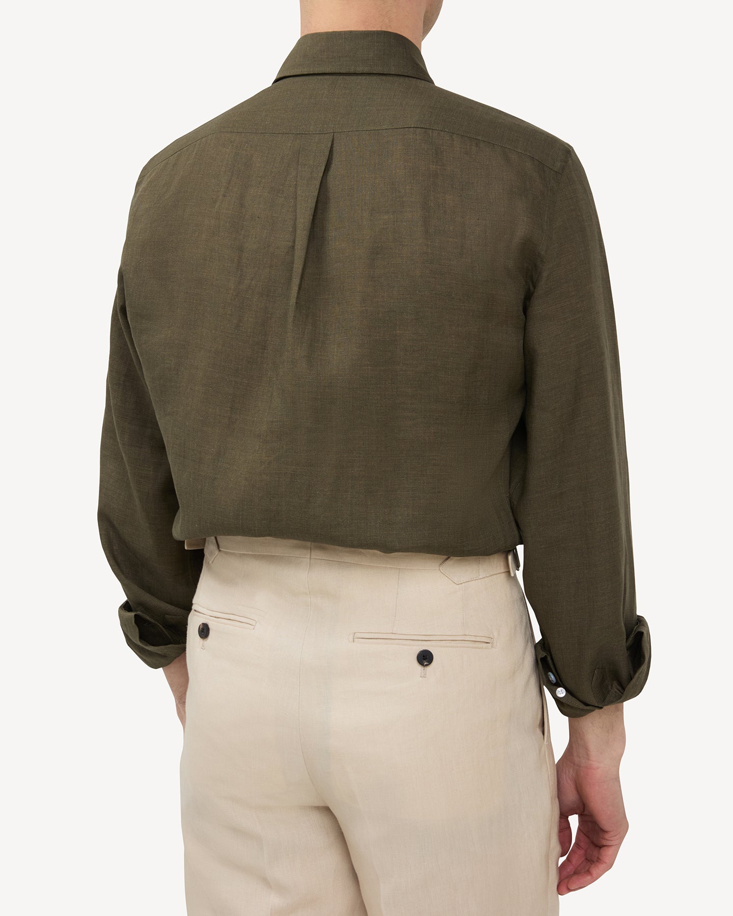 Man wearing olive green linen shirt and stone linen trousers