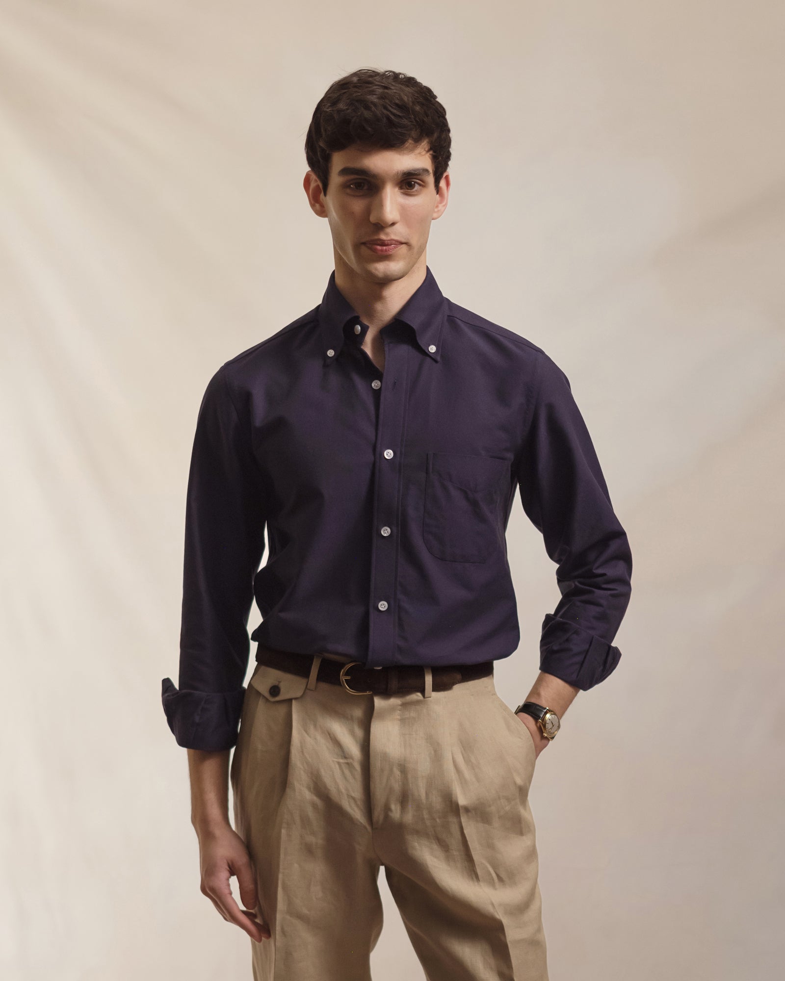 Man wearing a navy OCBD with taupe linen trousers