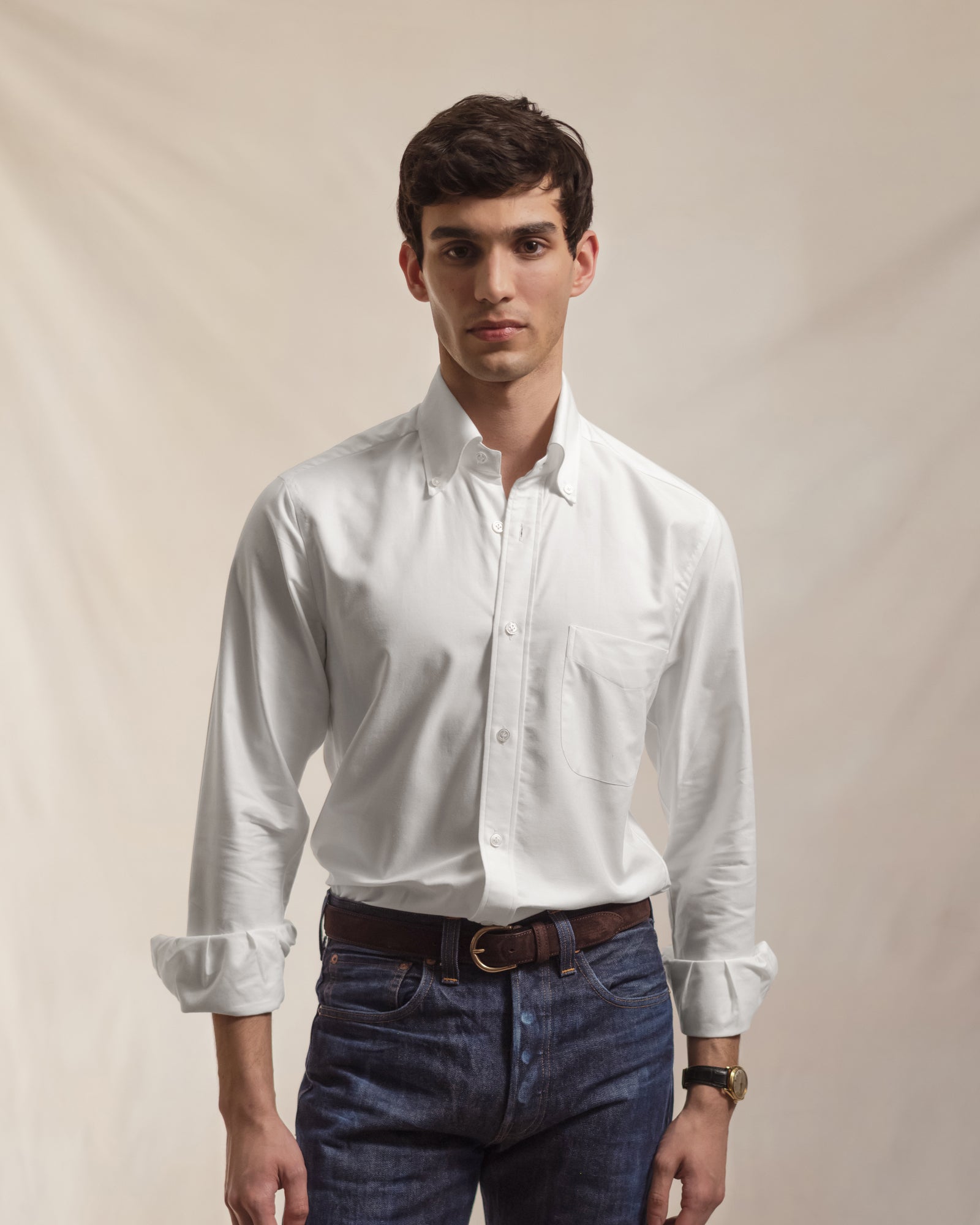 Man wearing a white OCBD shirt and raw denim jeans