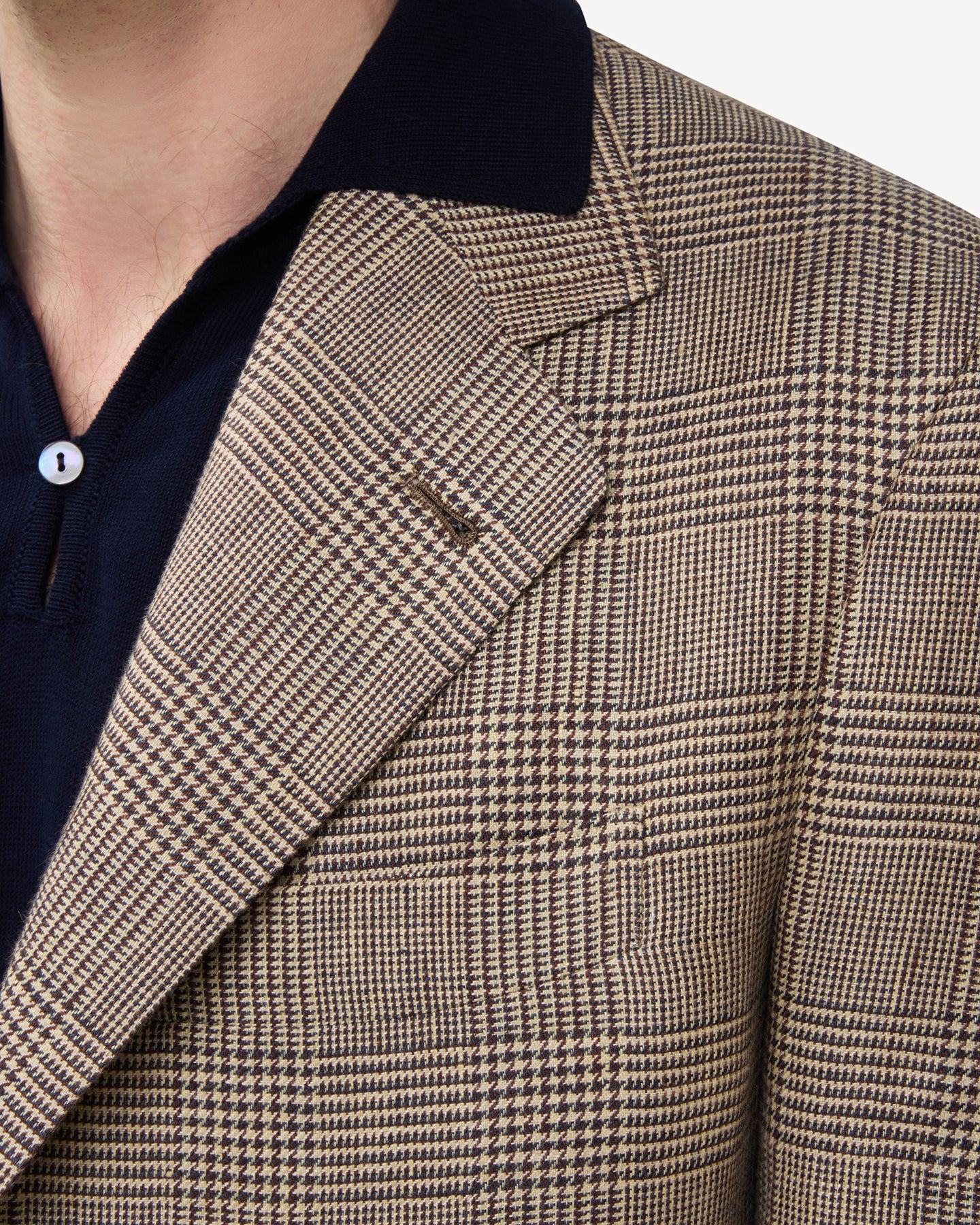 The lapel of a brown linen Prince of Wales sport coat