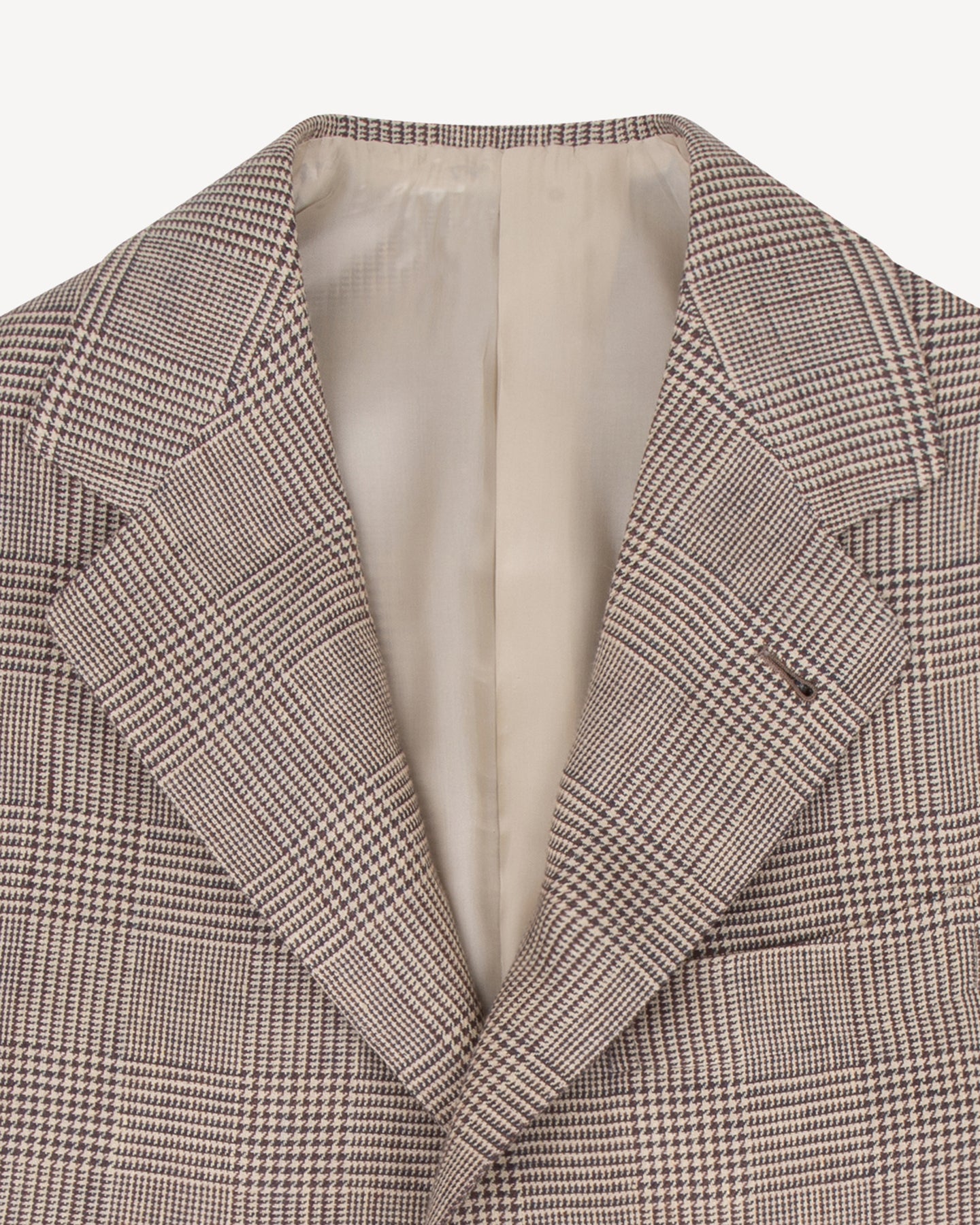 The lapel of a brown linen Prince of Wales sport coat