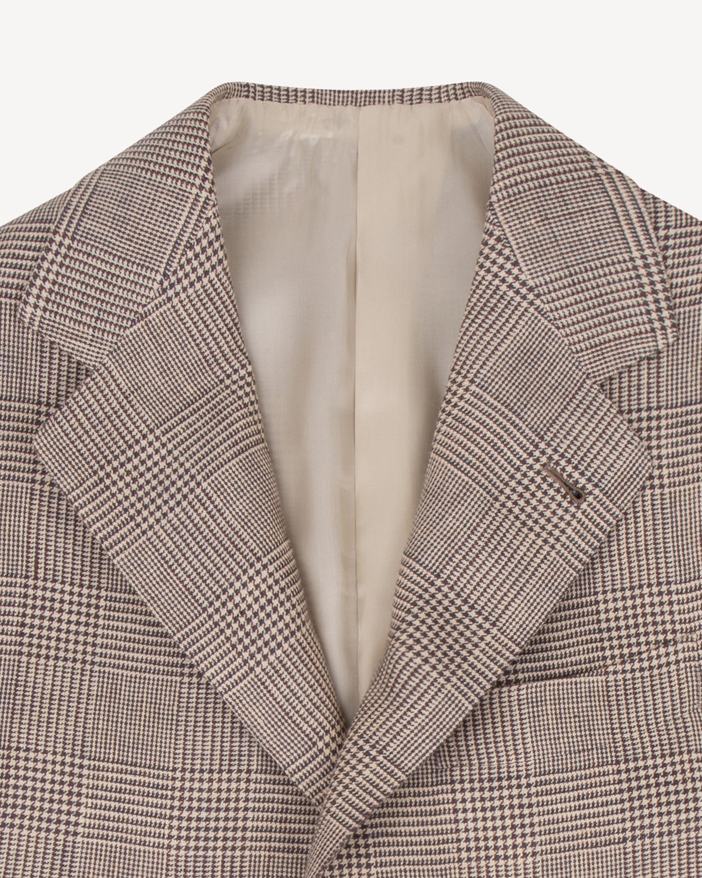 The lapel of a brown linen Prince of Wales sport coat