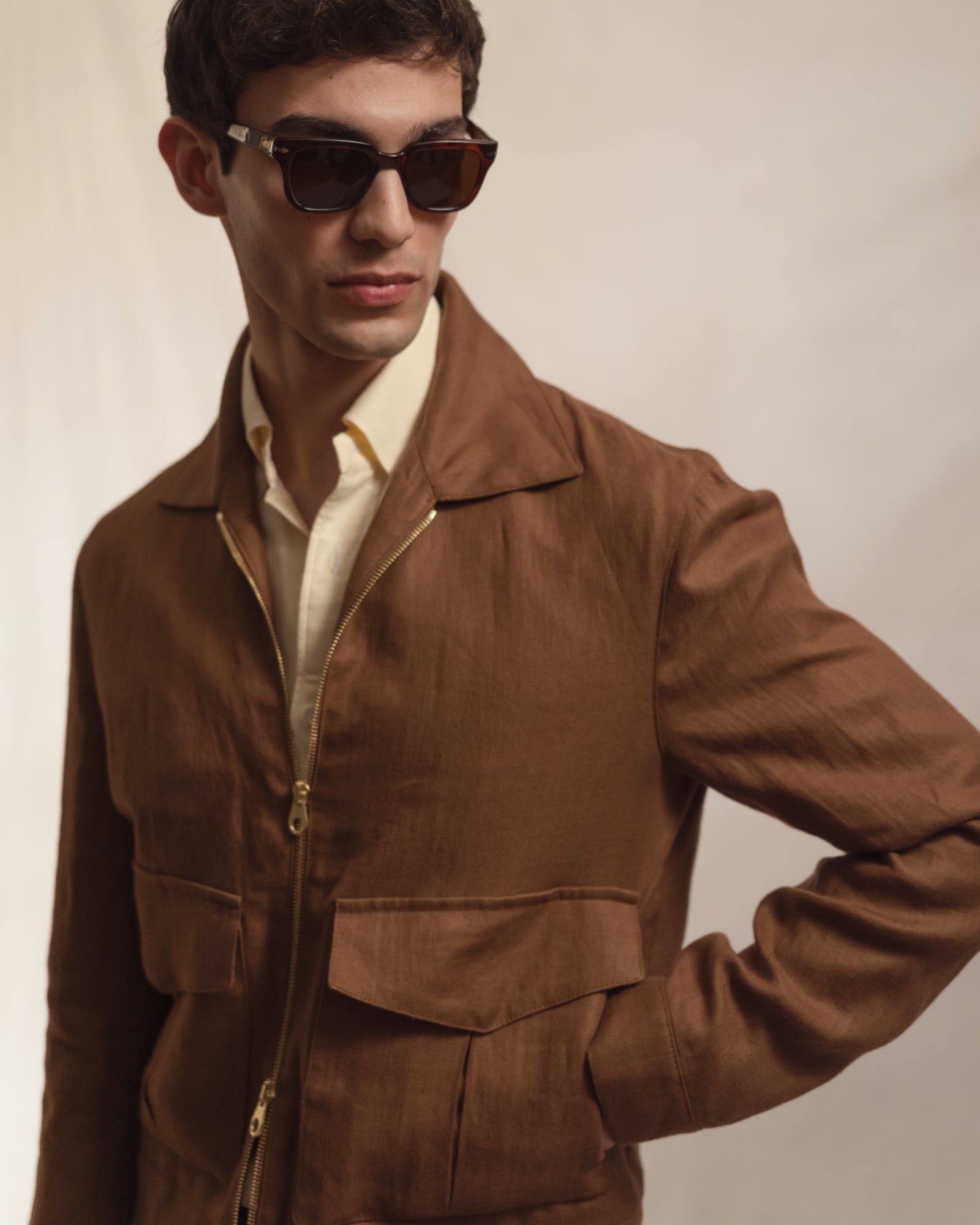 Man wearing a yellow OCBD with light brown linen flight jacket