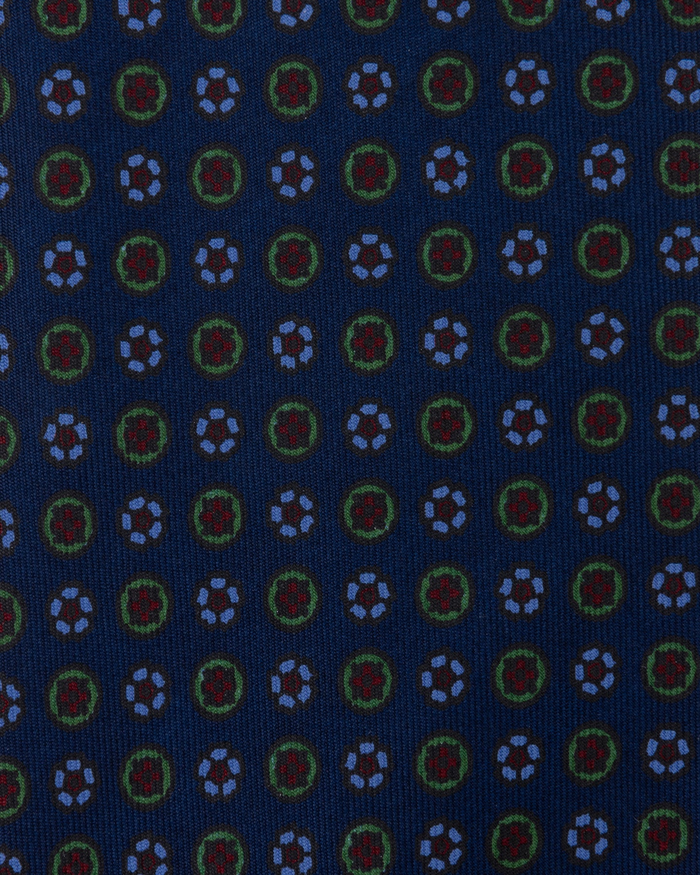 Dark blue Ancient Madder tie with small floral pattern in shades of light blue, green, and red.