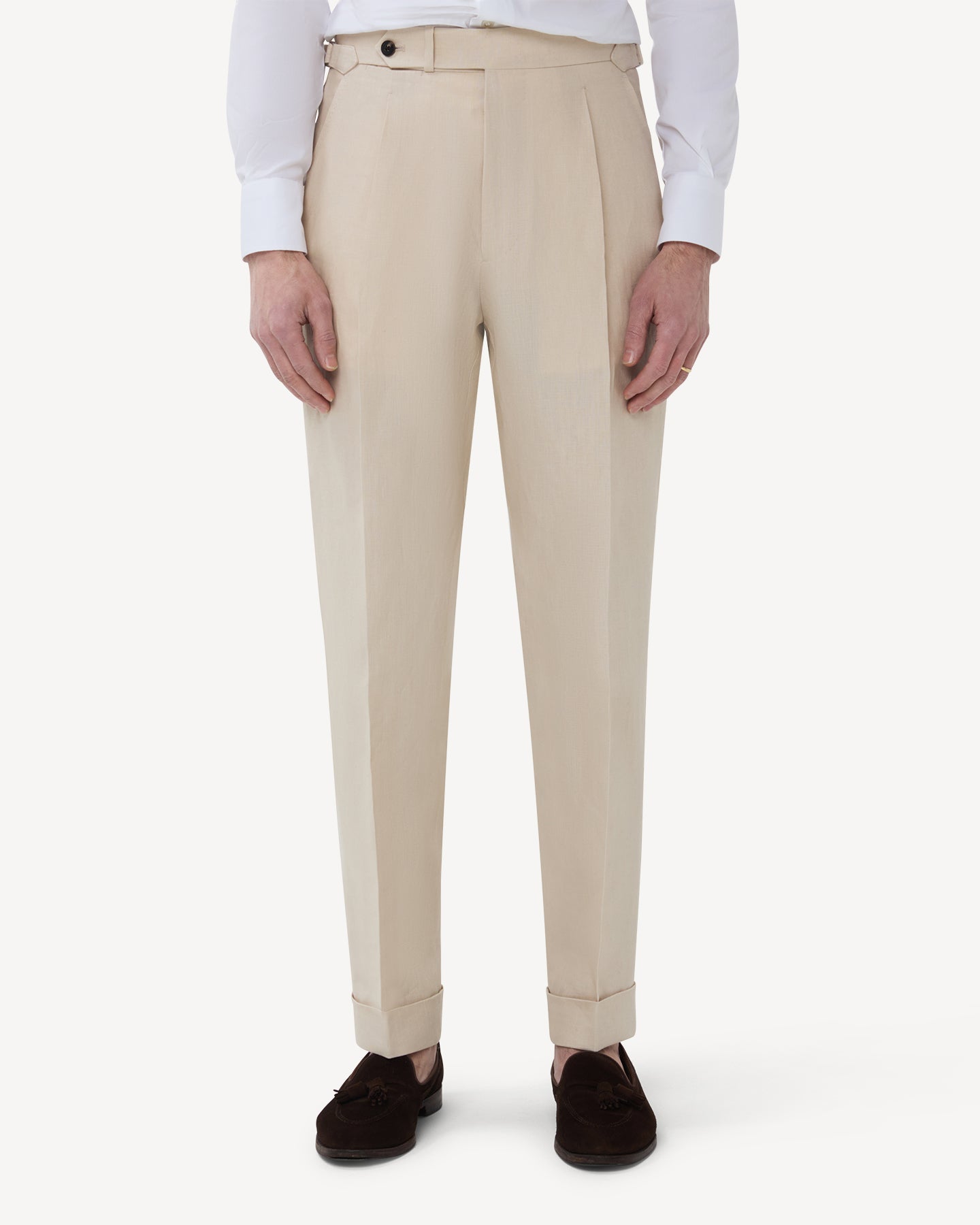 The front of stone linen trousers with single pleats and side adjusters