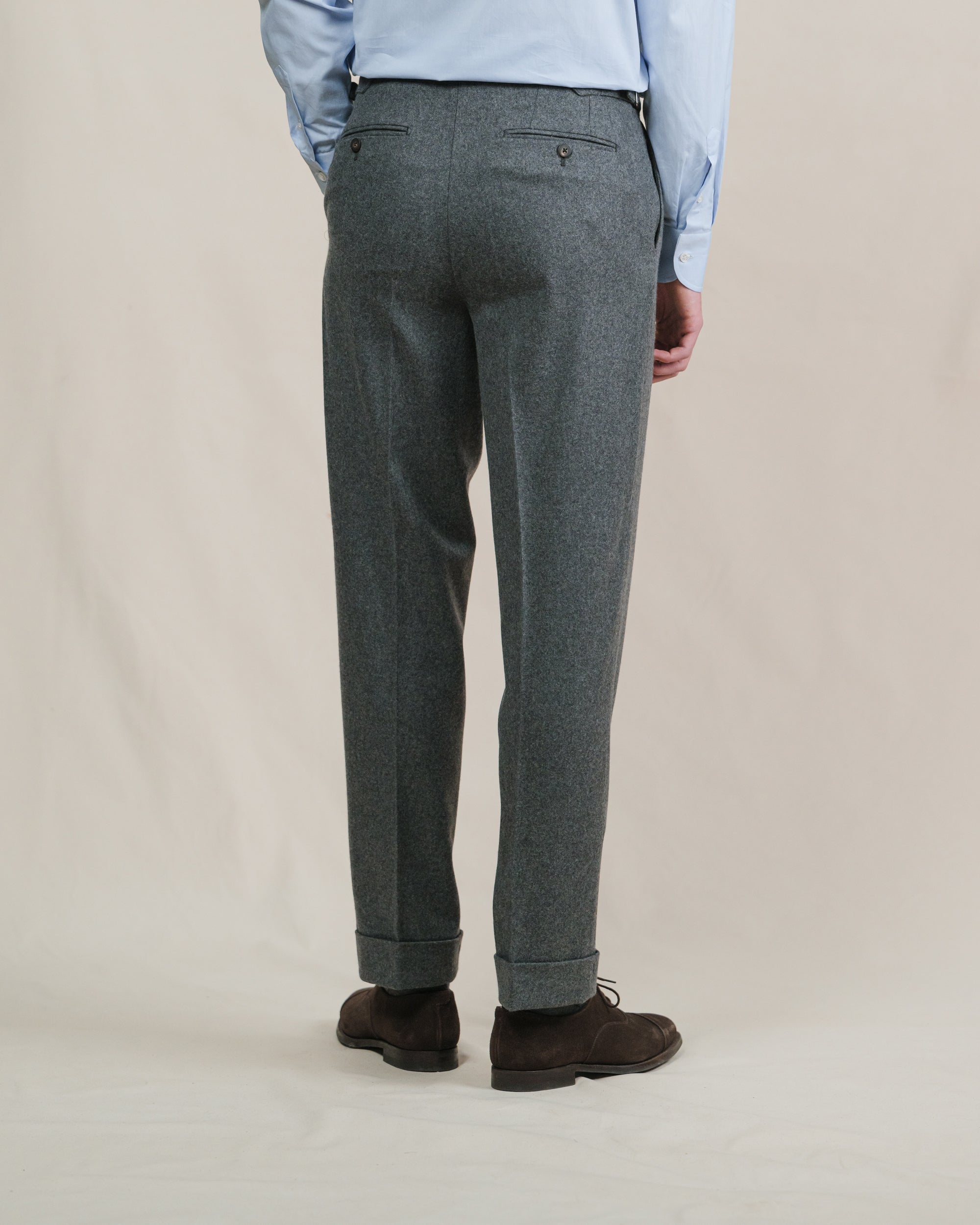 A person wearing a pair of mid grey flannel trousers