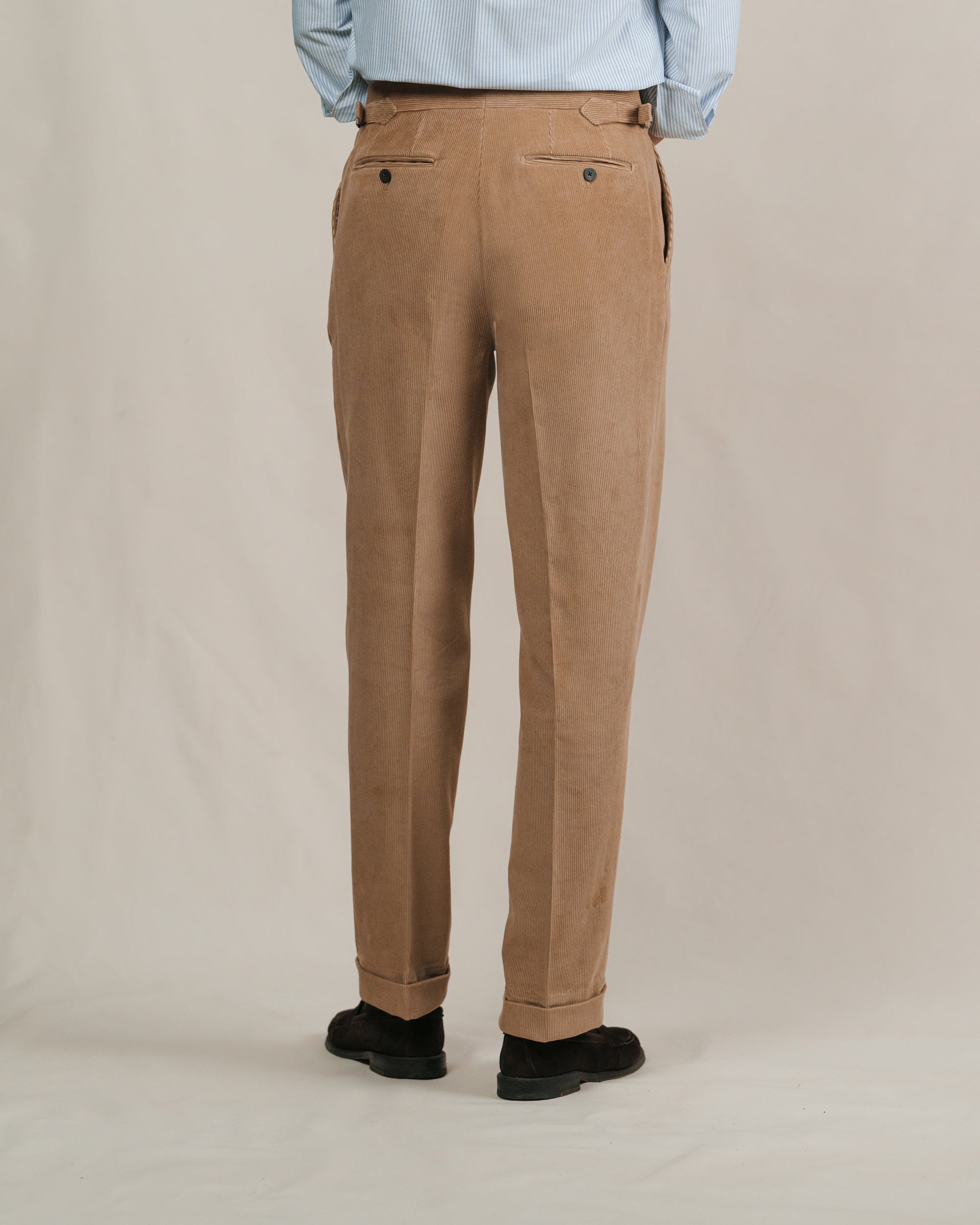 Brown pants worn by a person with a striped cotton shirt and brown suede loafers