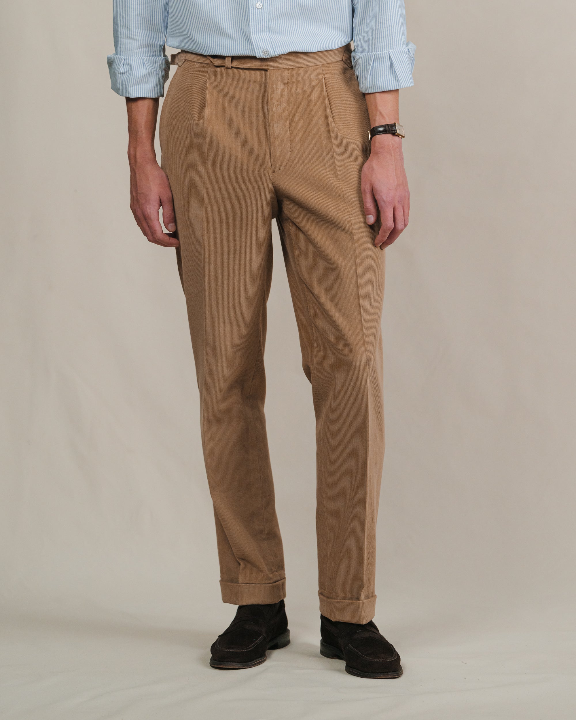 Person wearing brown corduroy trousers with brown suede penny loafers