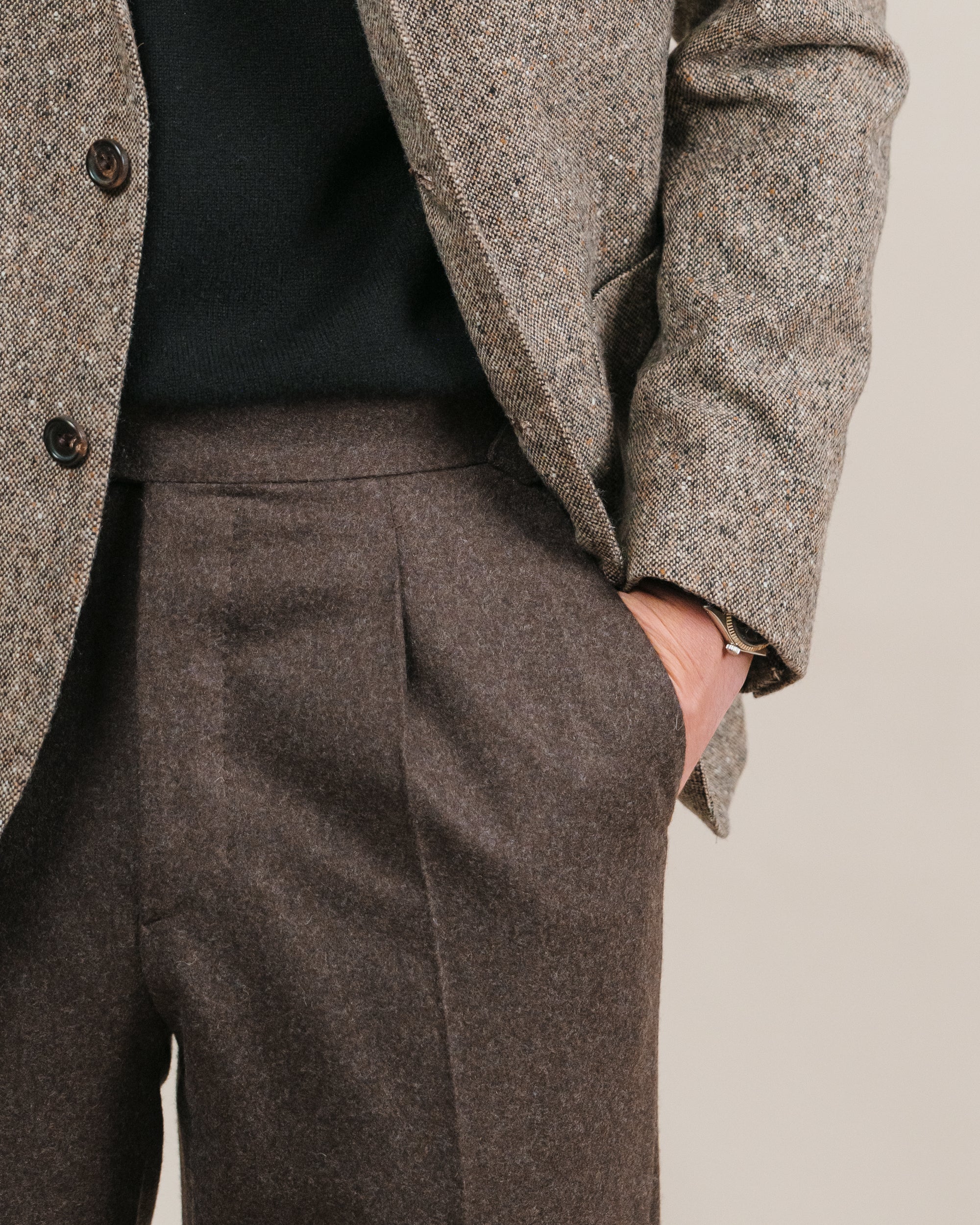 Person wearing a light brown donegal tweed jacket and brown flannel trousers