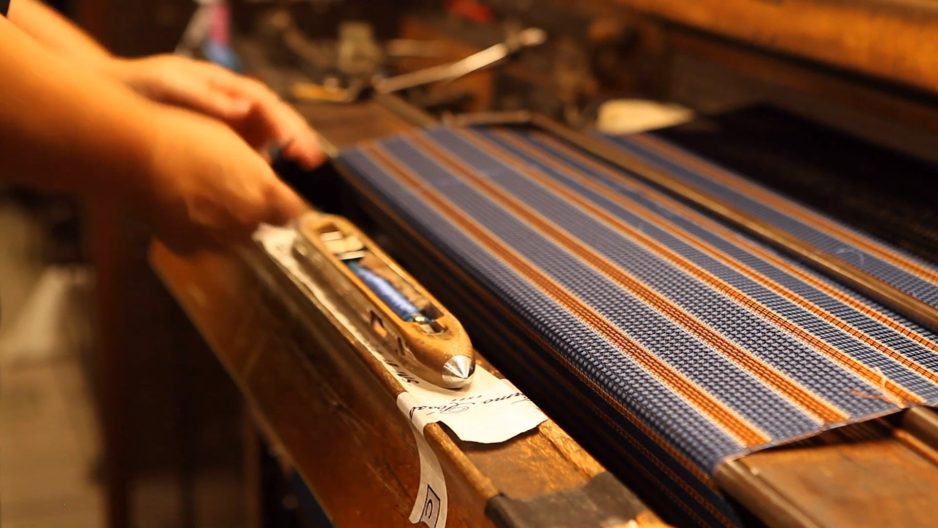 Person weaving grenadine silk on old wooden shuttle looms at silk weaver Fermo Fossati