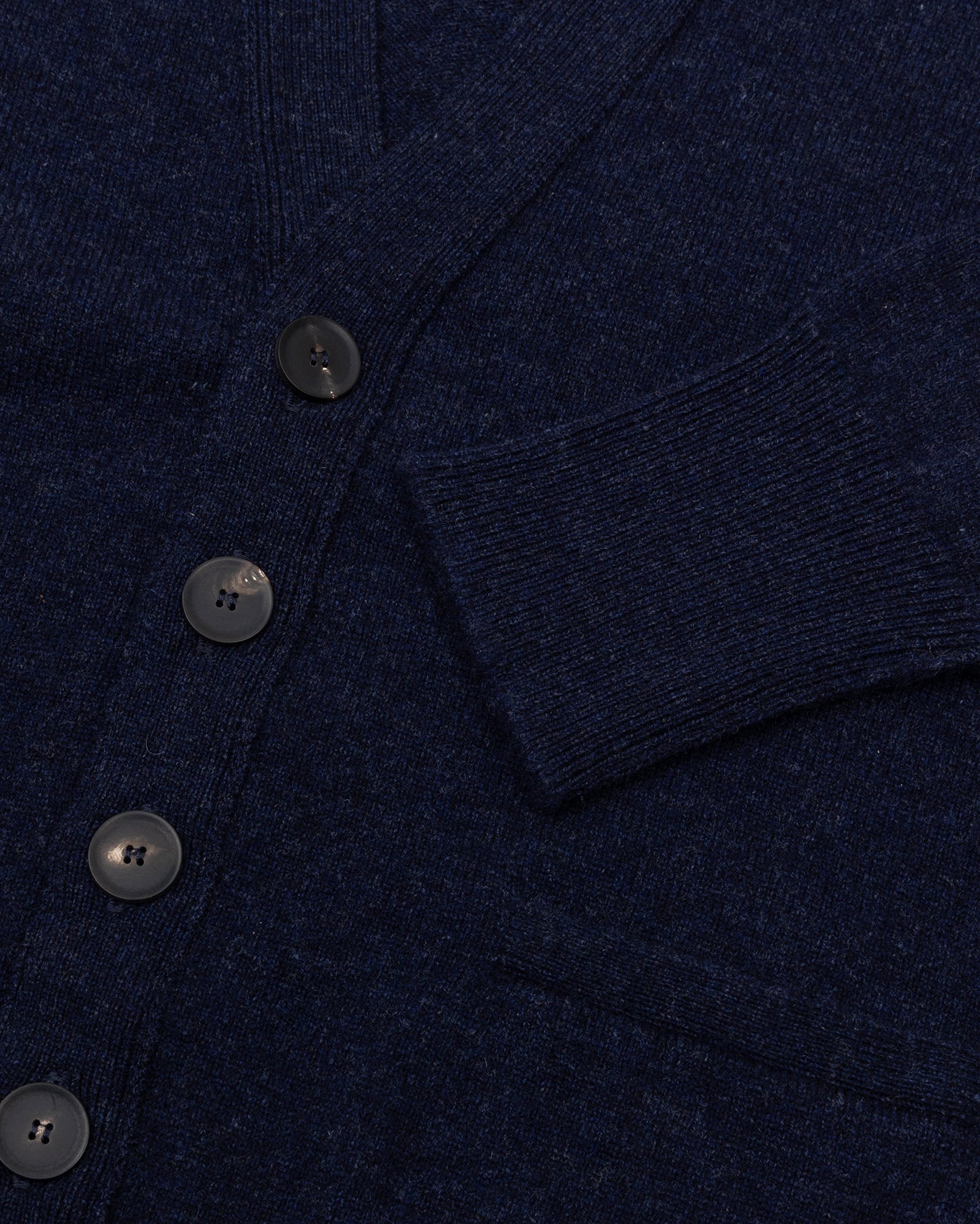 A dark blue lambswool cardigan with horn buttons and front pockets