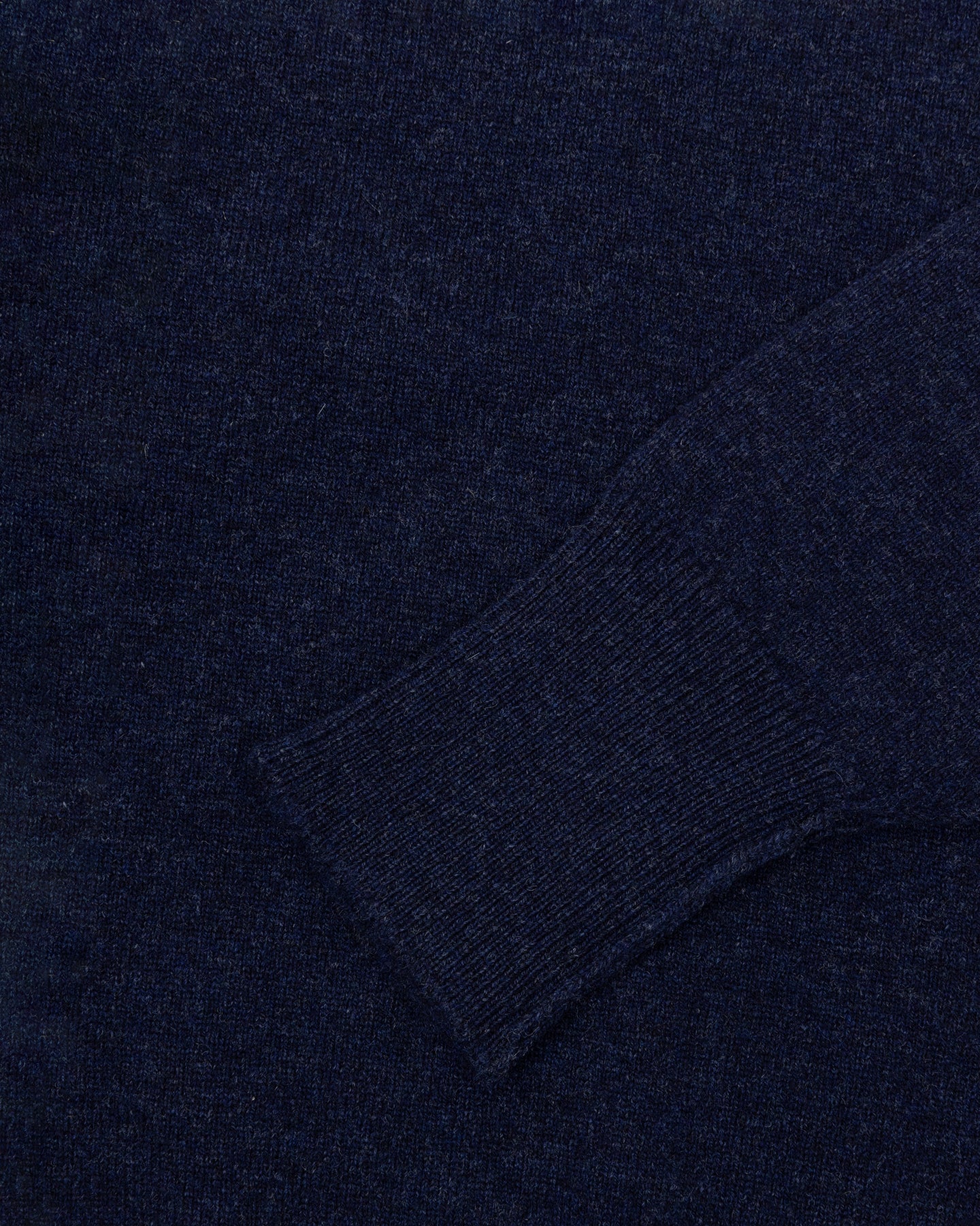 A dark blue lambswool sweater with turnback cuffs