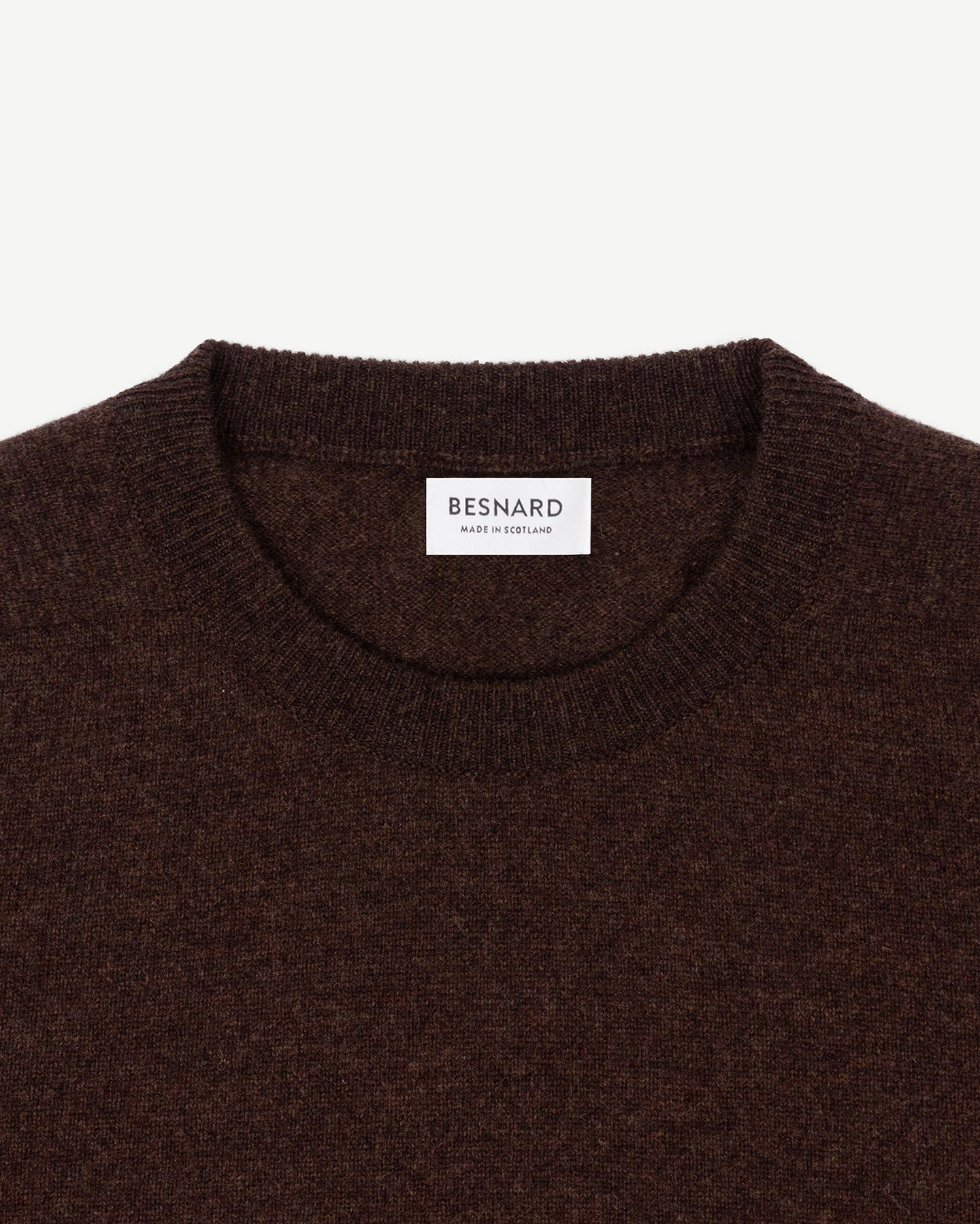 A dark brown lambswool crew neck sweater