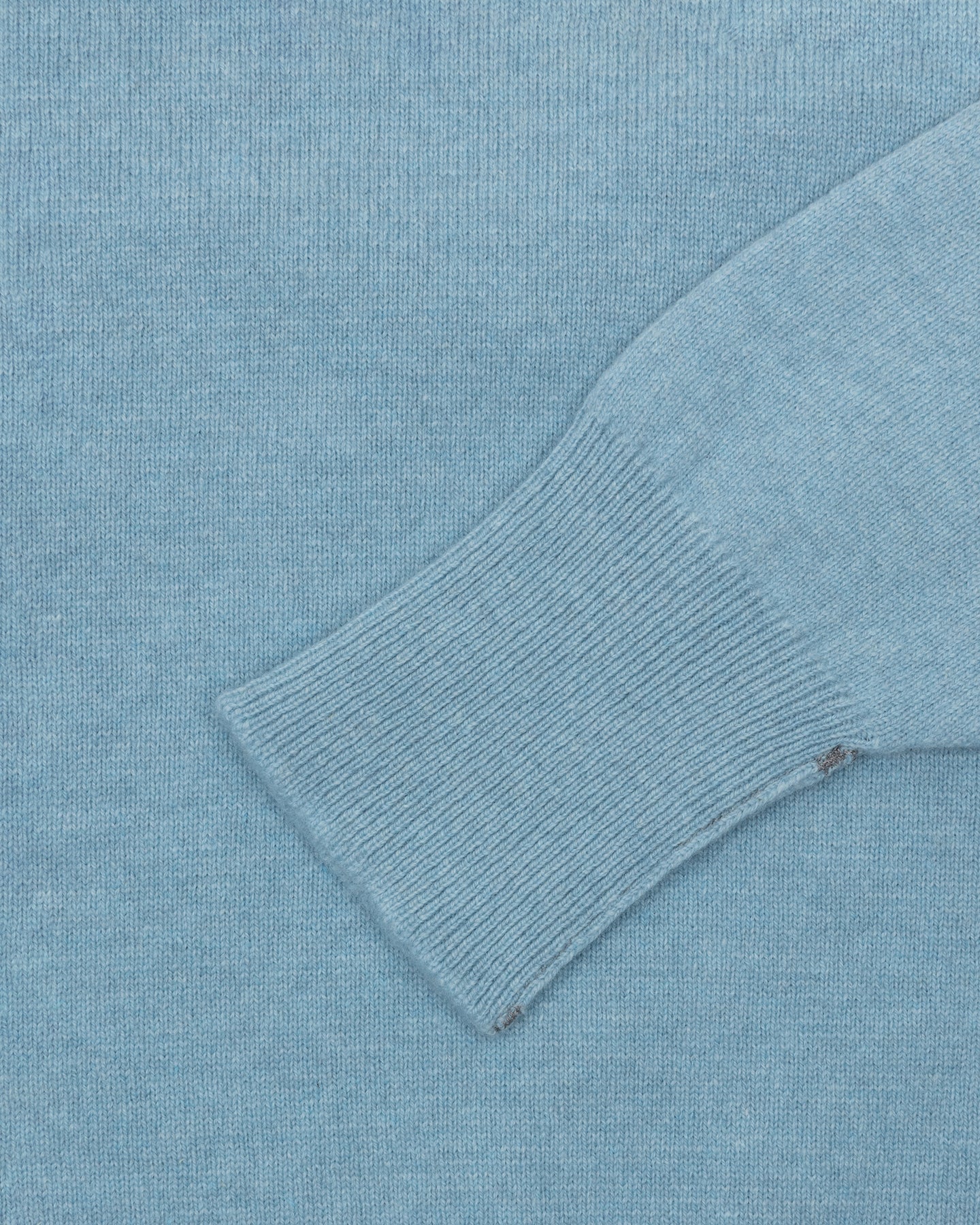 A light blue lambswool sweater with turnback cuffs