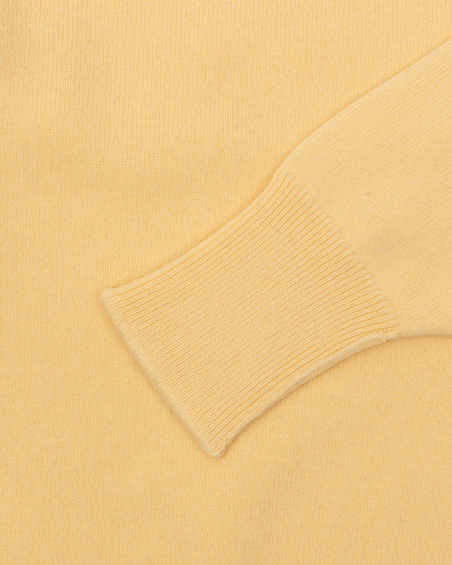 A yellow lambswool sweater with turnback cuffs