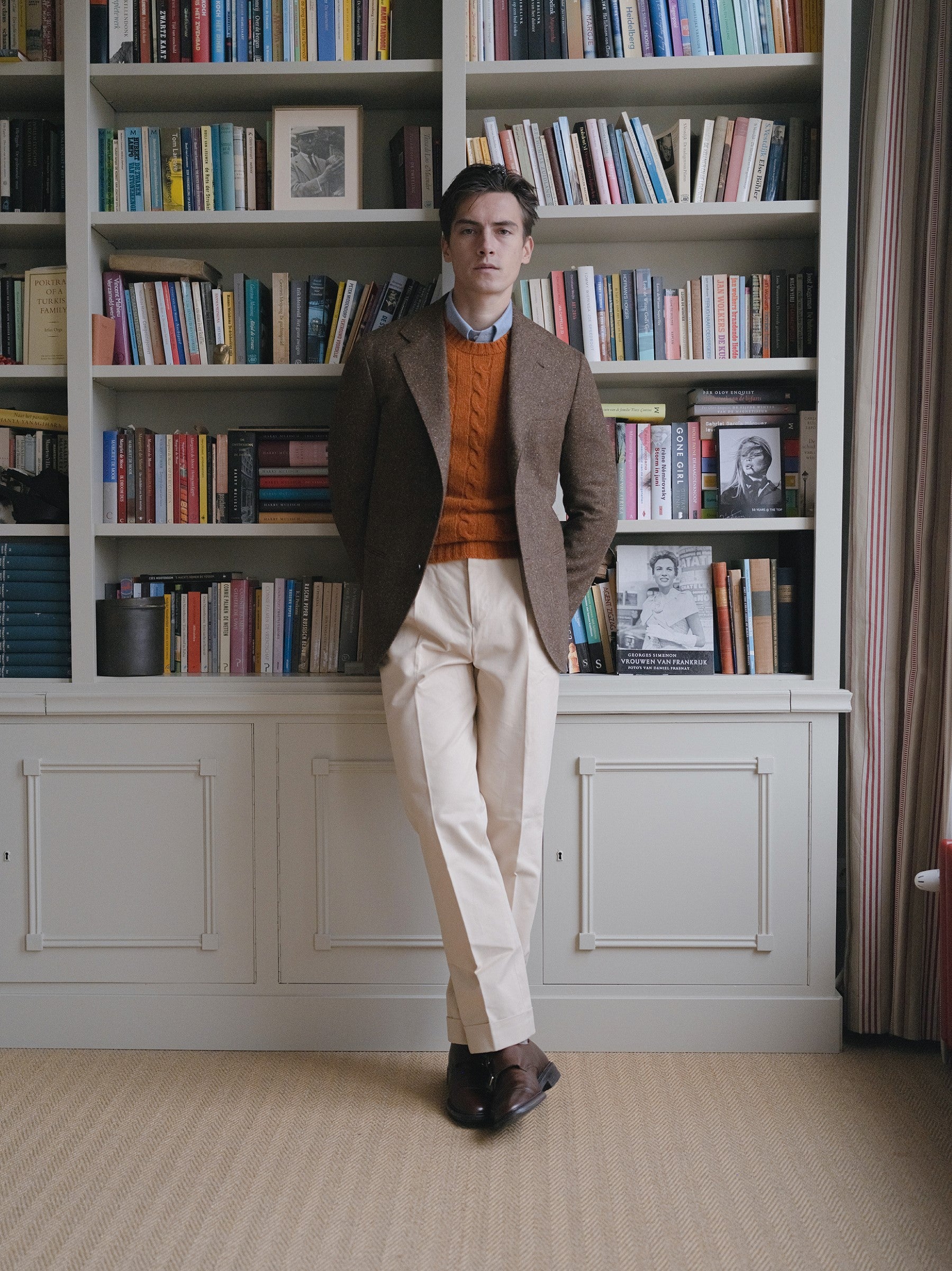 Man wearing a brown donegal tweed sport coat, burnt orange shetland sweater and cream cotton drill trousers