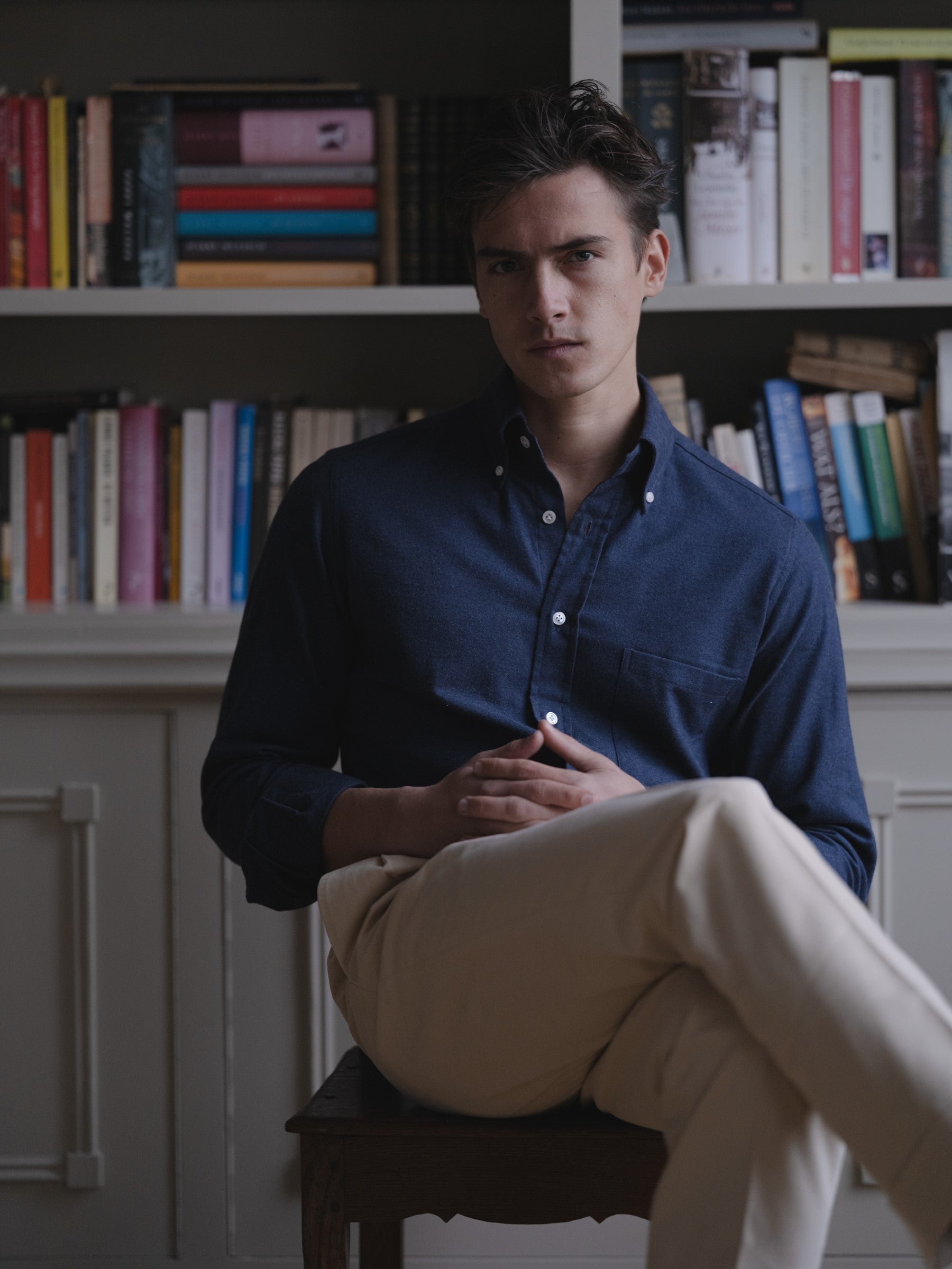 Man wearing a navy cotton cashmere button down shirt and cream cotton drill trousers
