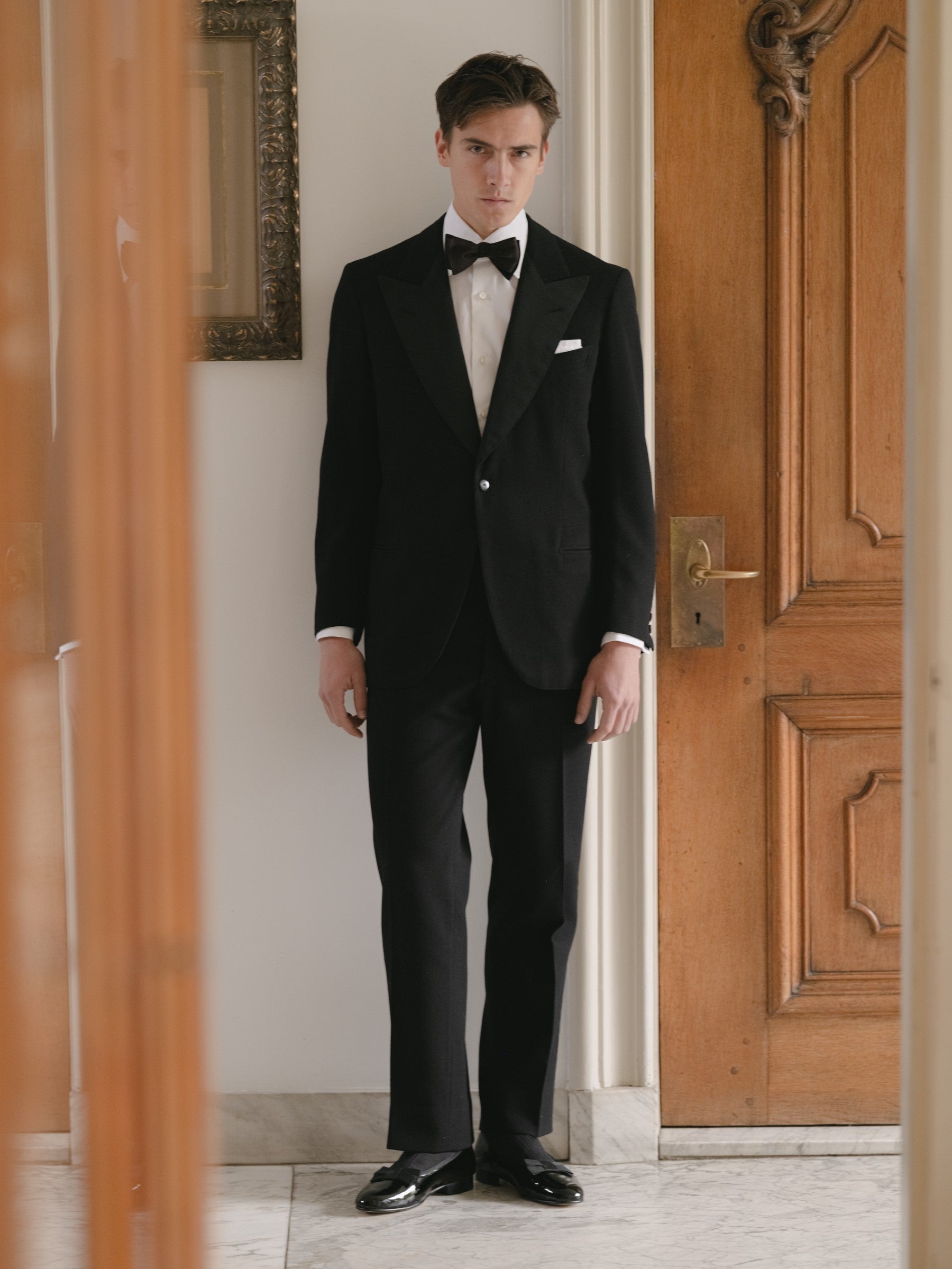 Man wearing a single breasted peak label tuxedo with black patent opera pumps