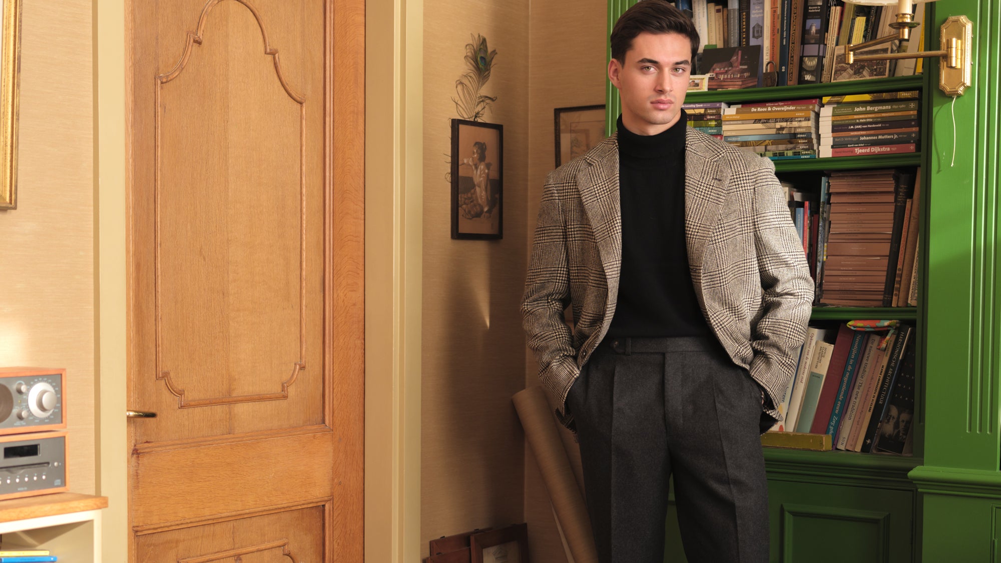 Man wearing a prince of wales tweed jacket, black roll neck sweater and brown flannel trousers