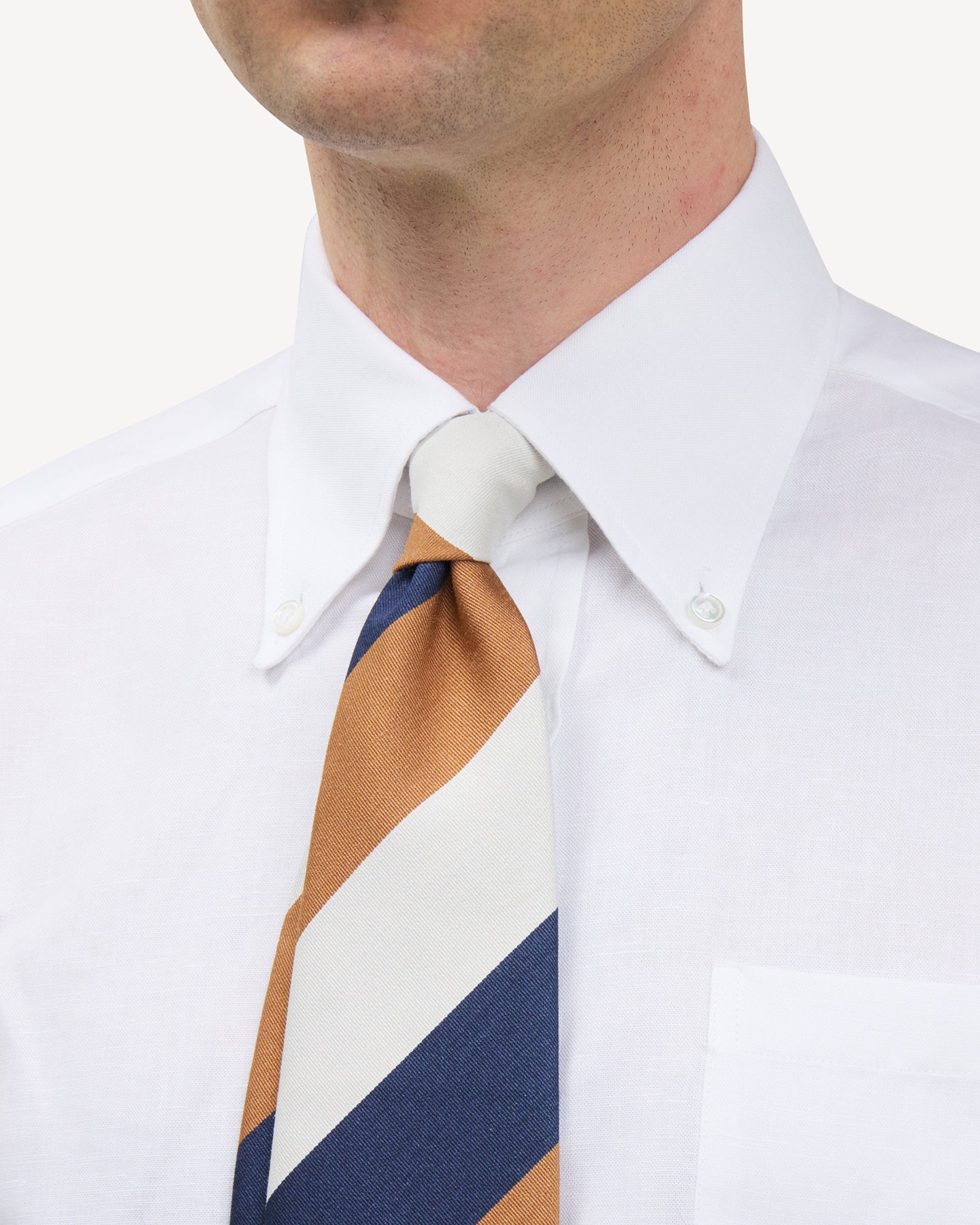 Man wearing white button down shirt and Navy, Cream, Ochre Block Stripe Mogador Tie