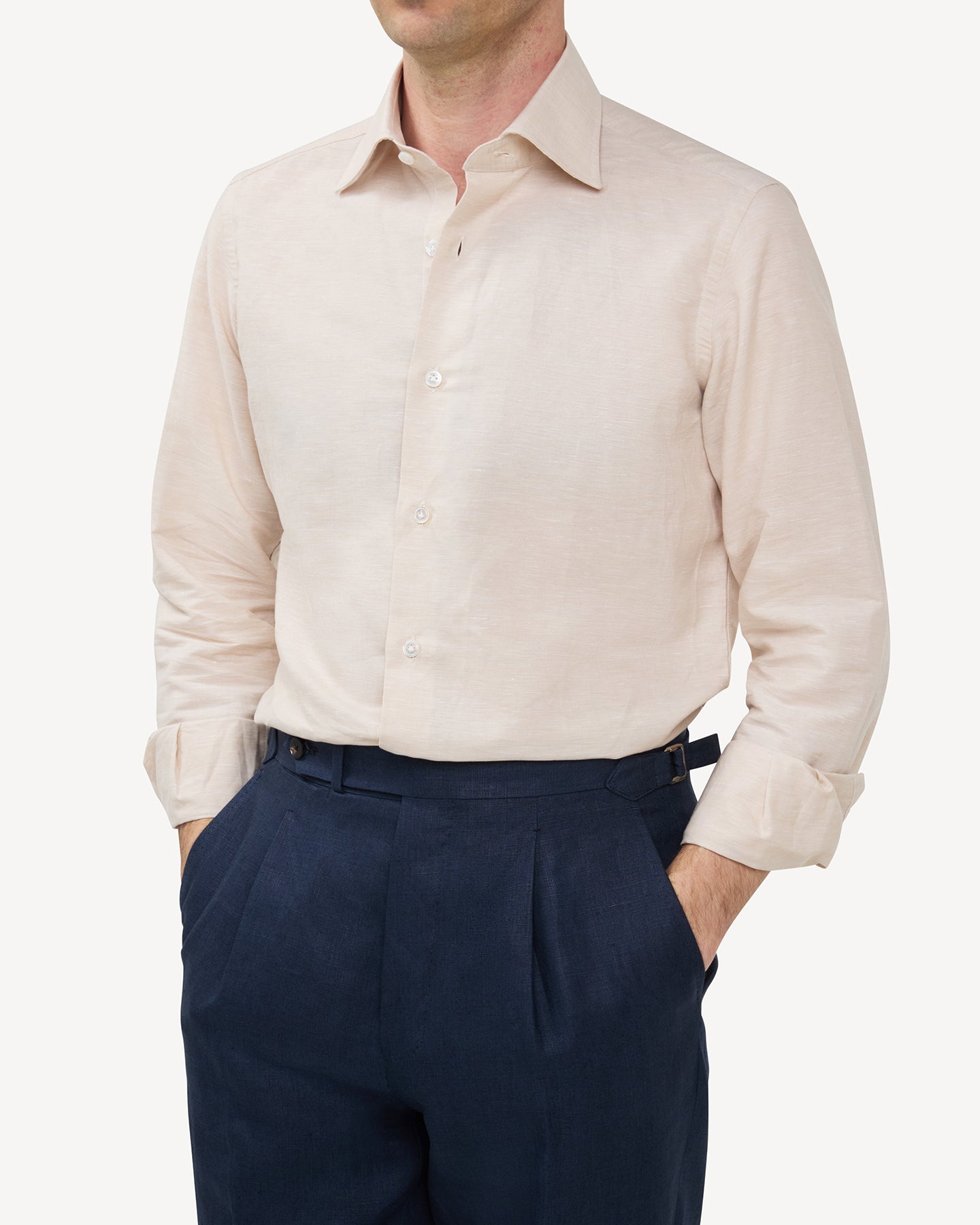 Man wearing a beige cotton linen dress shirt and navy linen trousers