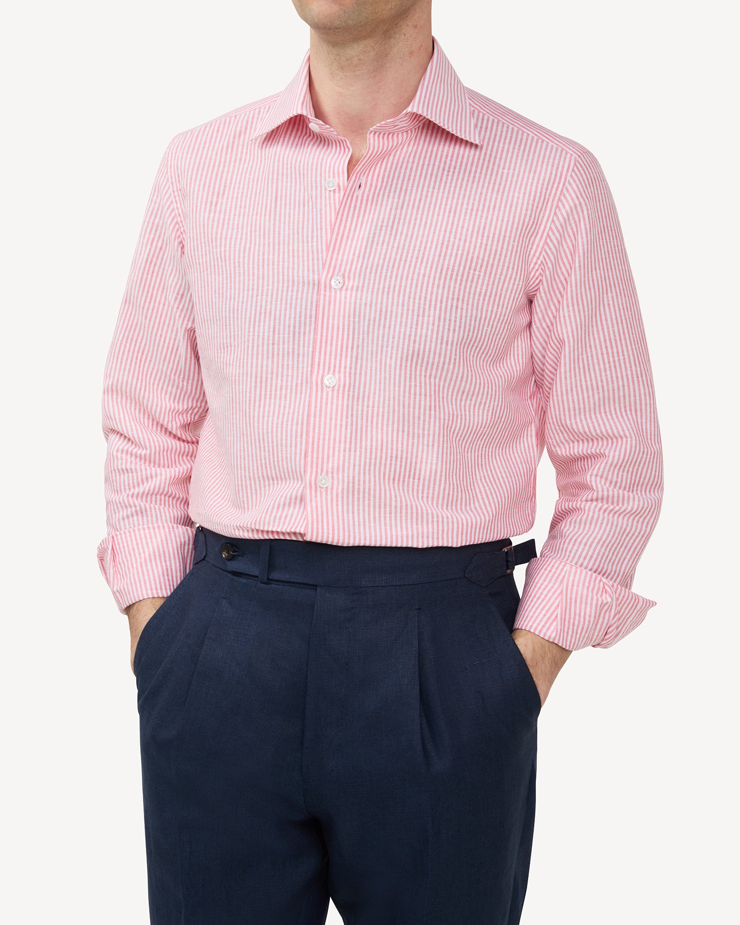 Man wearing a red bengal stripe cotton linen shirt and navy linen trousers