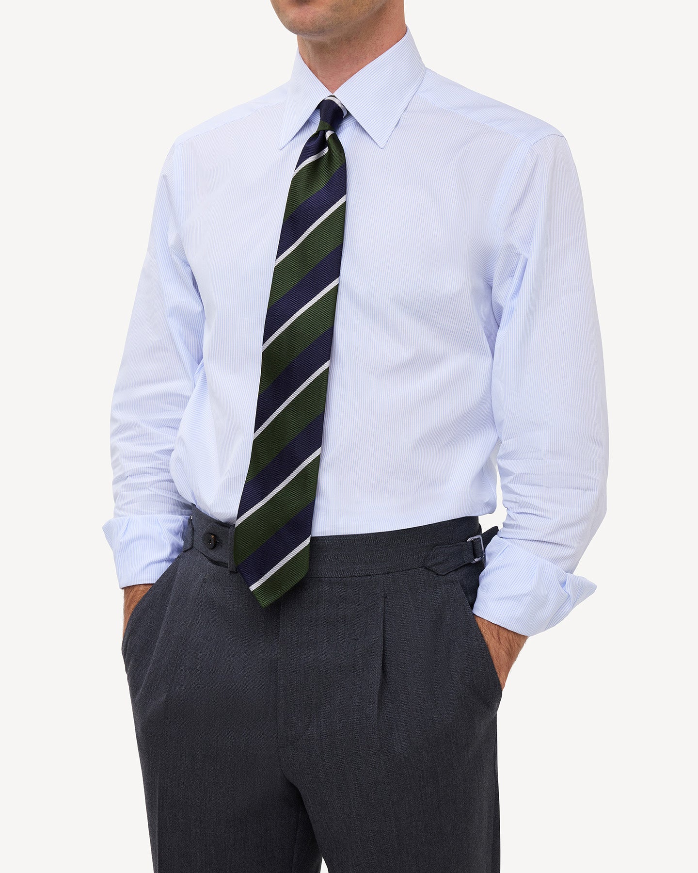 Man wearing a light blue hairline stripe poplin shirt with a point collar and a green, navy and white regimental repp tie