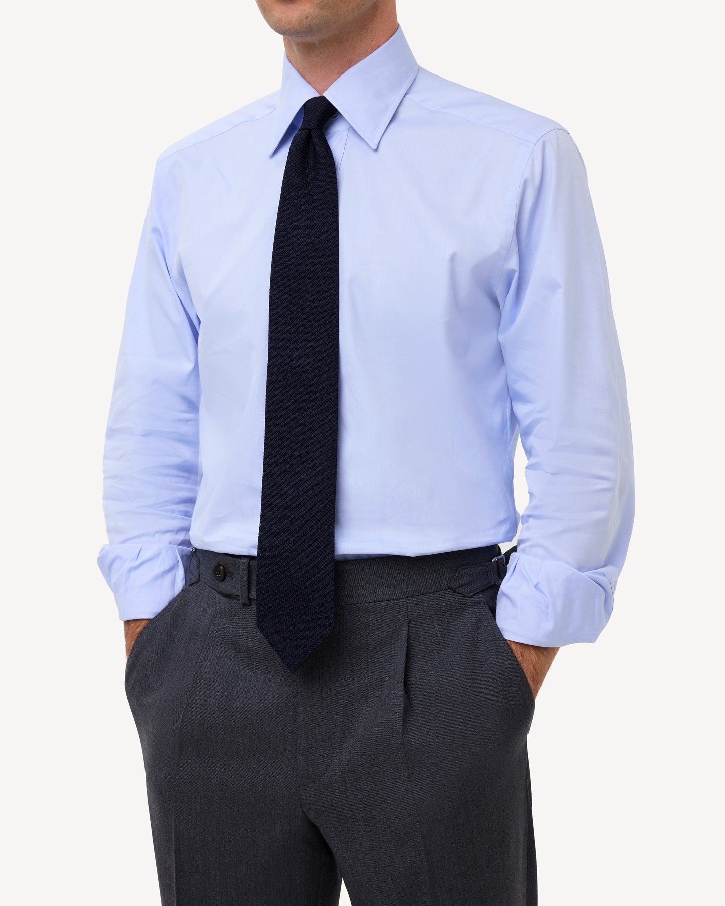 Man wearing a light blue oxford pinpoint shirt with a point collar and a navy grenadine tie