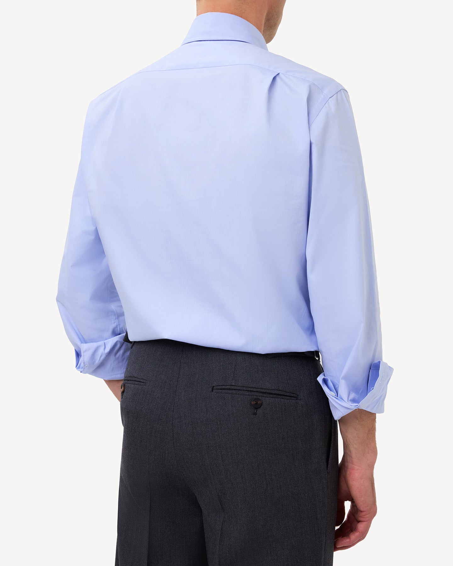 Man wearing a light blue pinpoint oxford shirt with knife pleats in the back