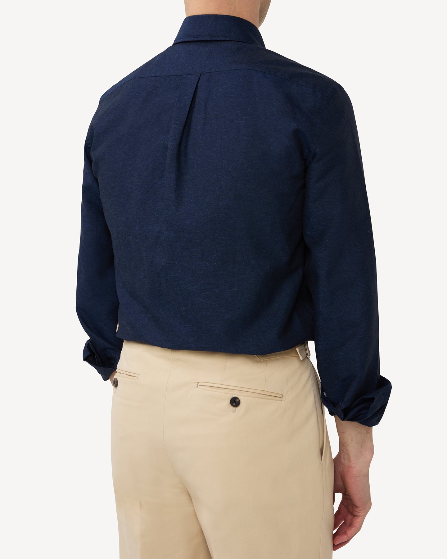 Man wearing a navy summer OCBD shirt with stone cotton trousers