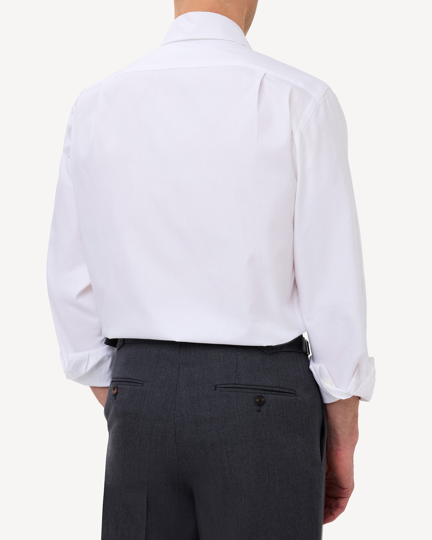 Man wearing a white pinpoint oxford shirt with knife pleats in the back