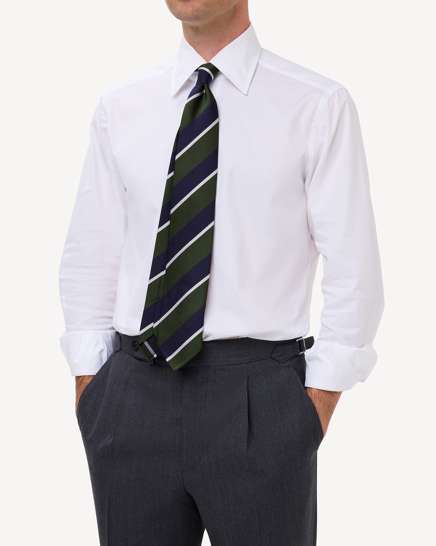 Man wearing a white oxford pinpoint shirt with a point collar and and a green, navy and white regimental repp tie