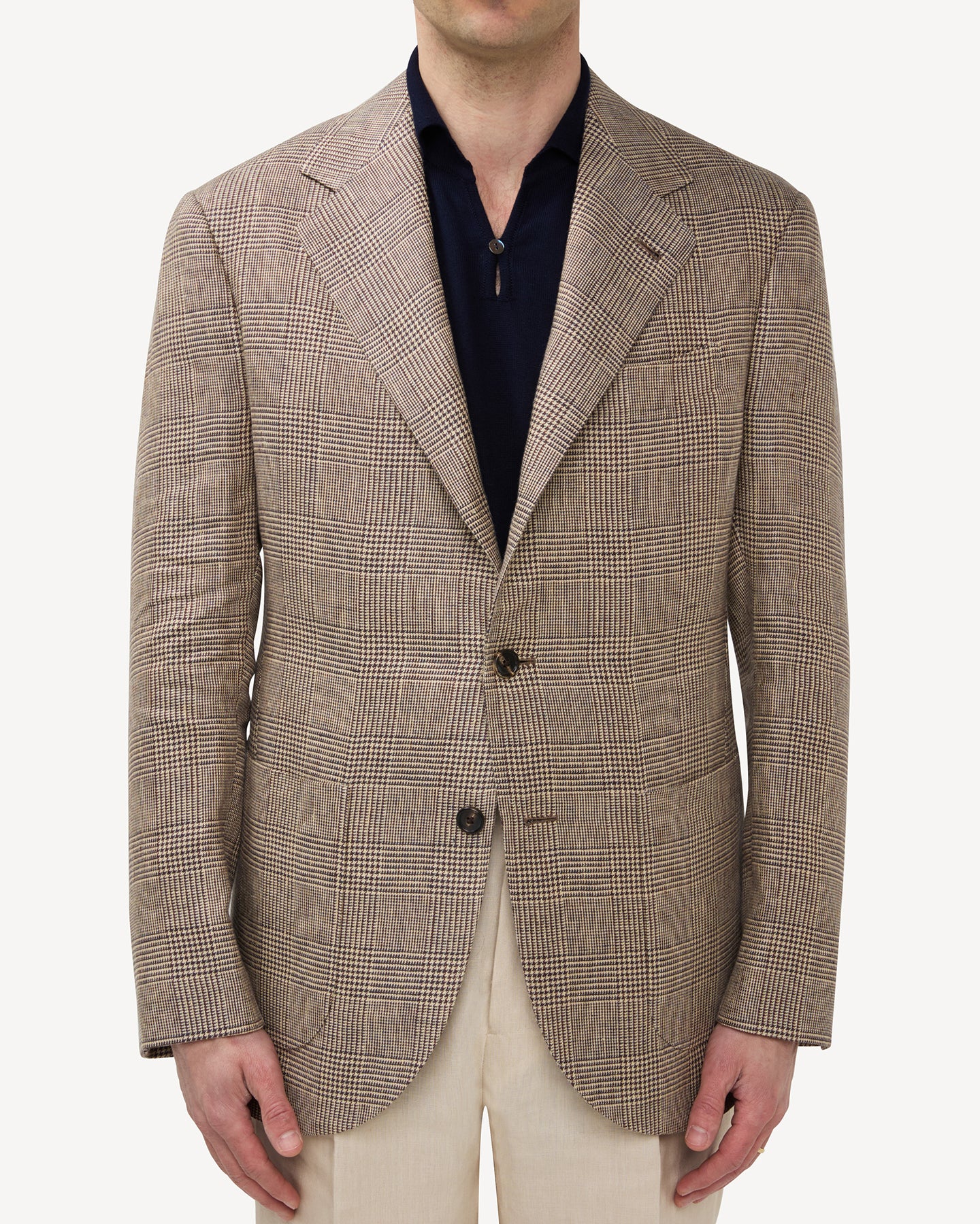 Man wearing a brown linen Prince of Wales sport coat with a navy skipper polo