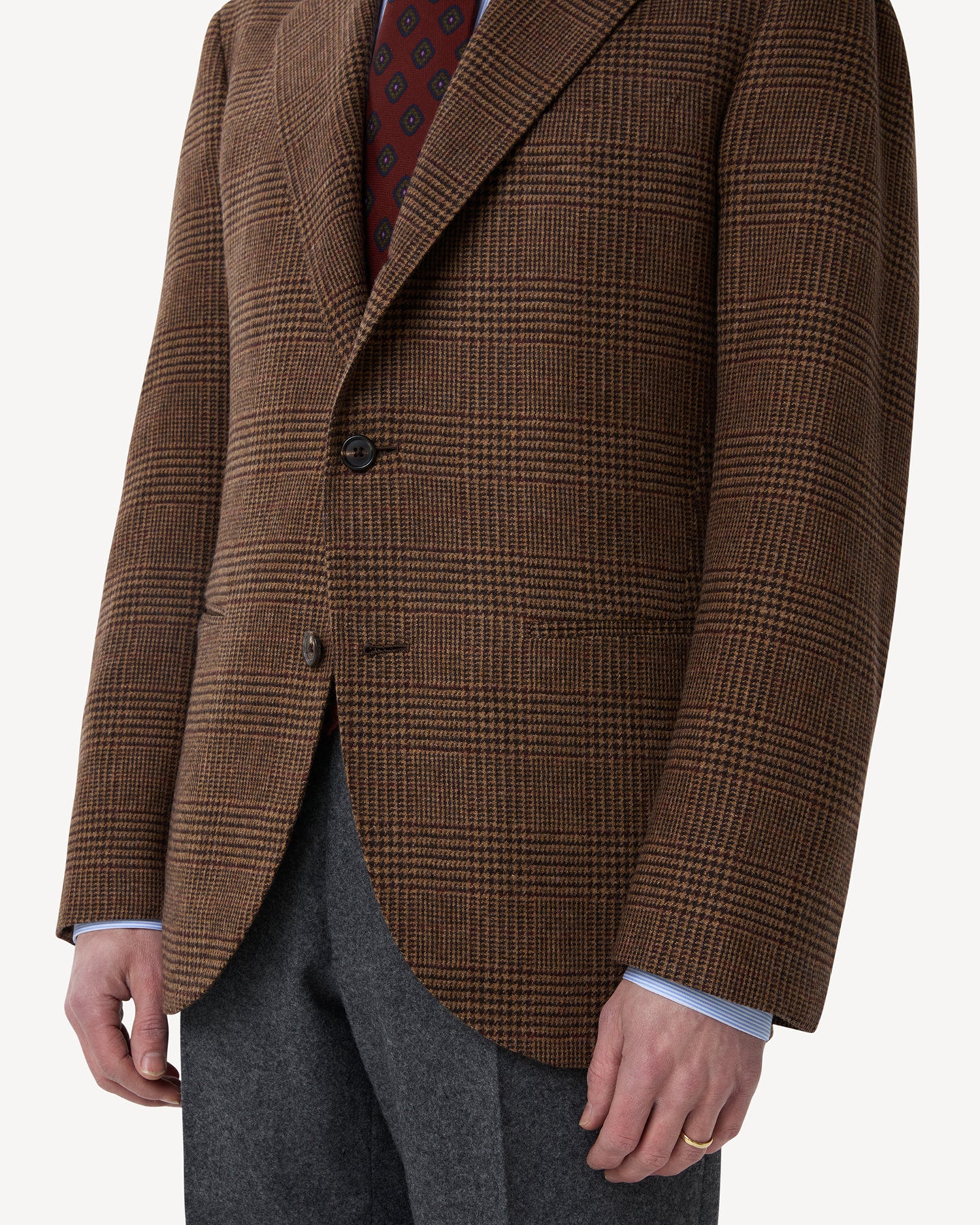 A man wearing a Brown Prince of Wales Merino Wool Sport Coat with jetted pockets