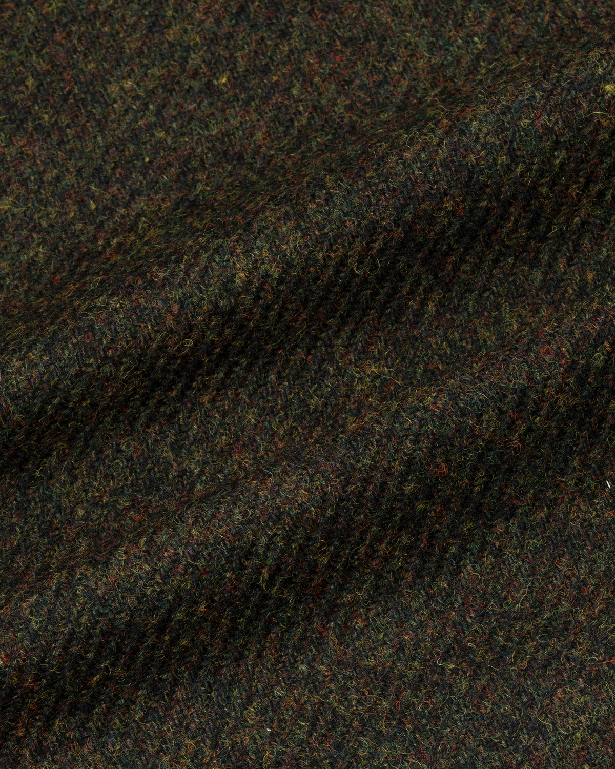 Detail van donkergroene merino twill met spikkels roest en oker