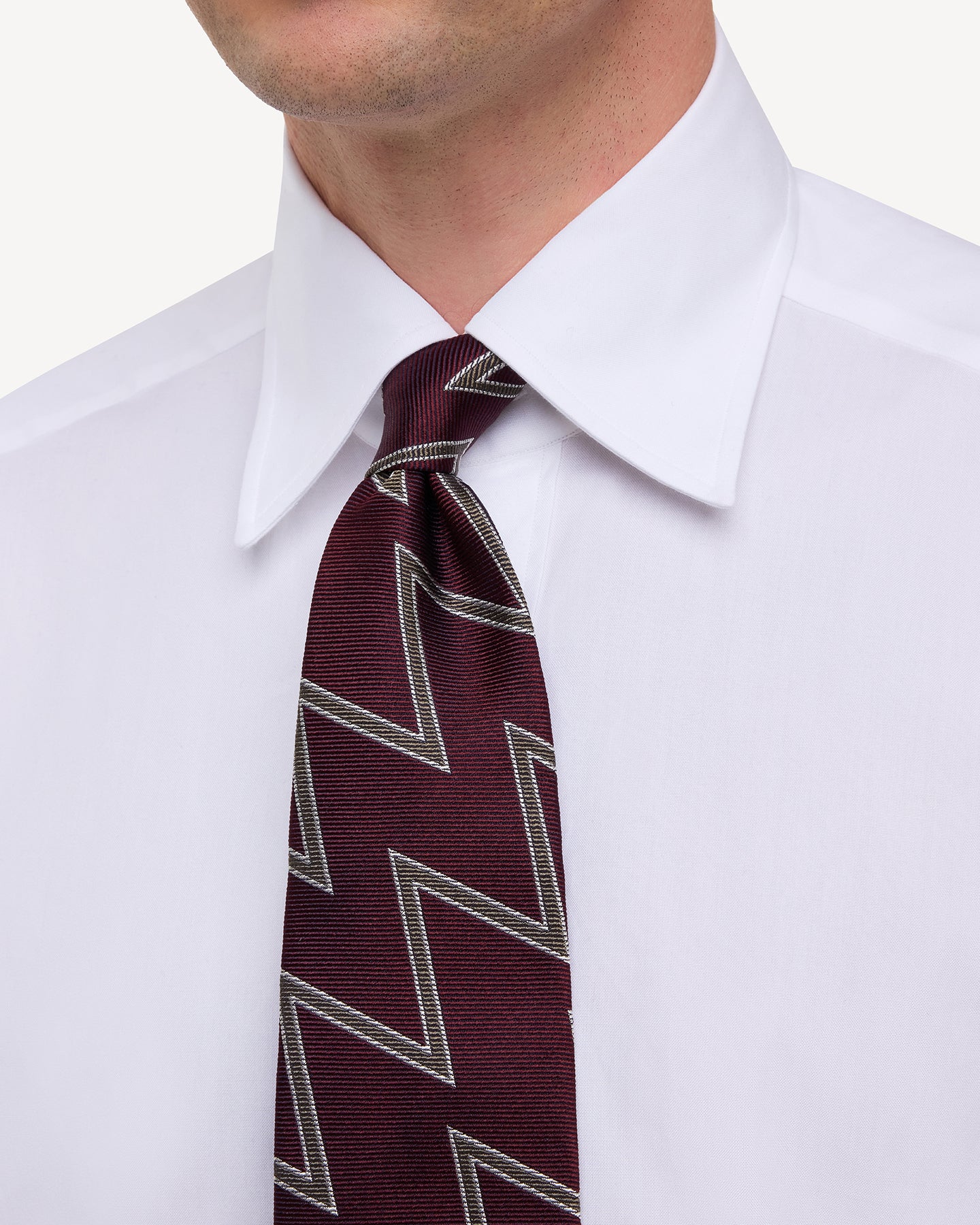 Man wearing white point collar shirt with Burgundy Brown and White Royal Artillery Regimental Tie