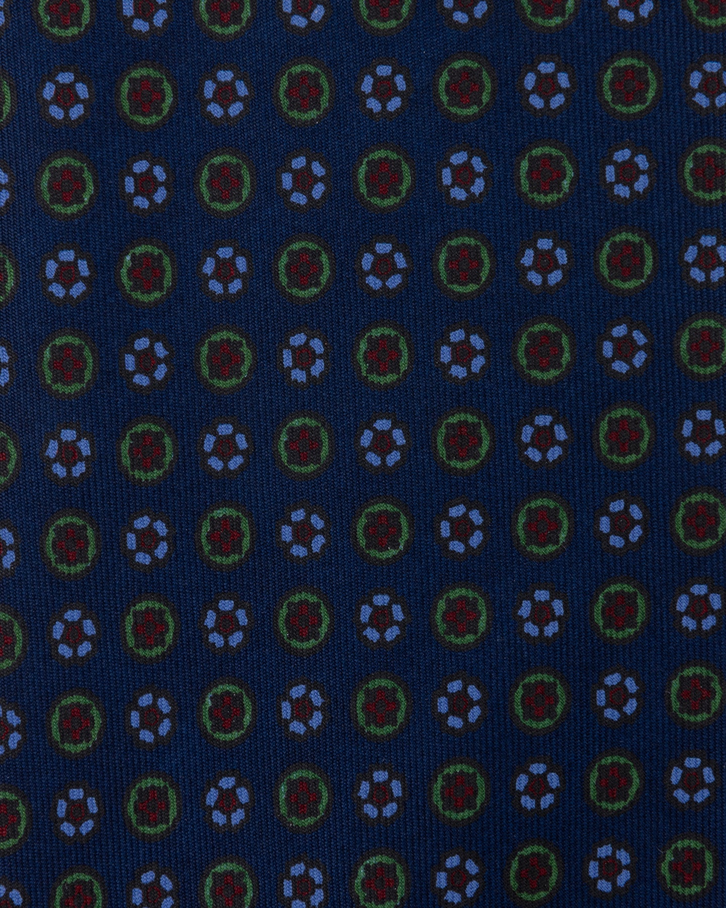 Dark blue Ancient Madder tie with small floral pattern in shades of light blue, green, and red.