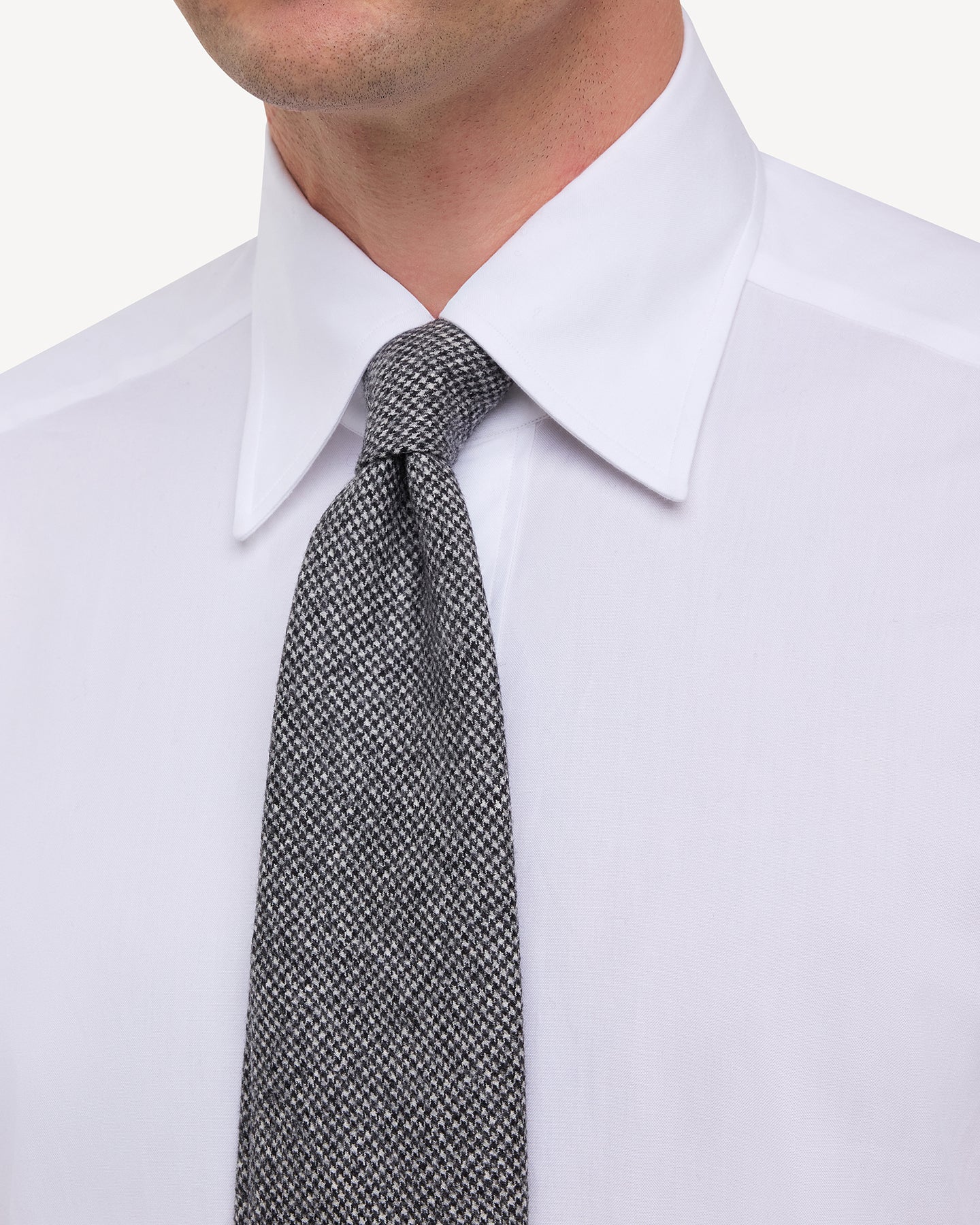 Man wearing white point collar shirt with Grey Fox Brothers Worsted Flannel Houndstooth Tie