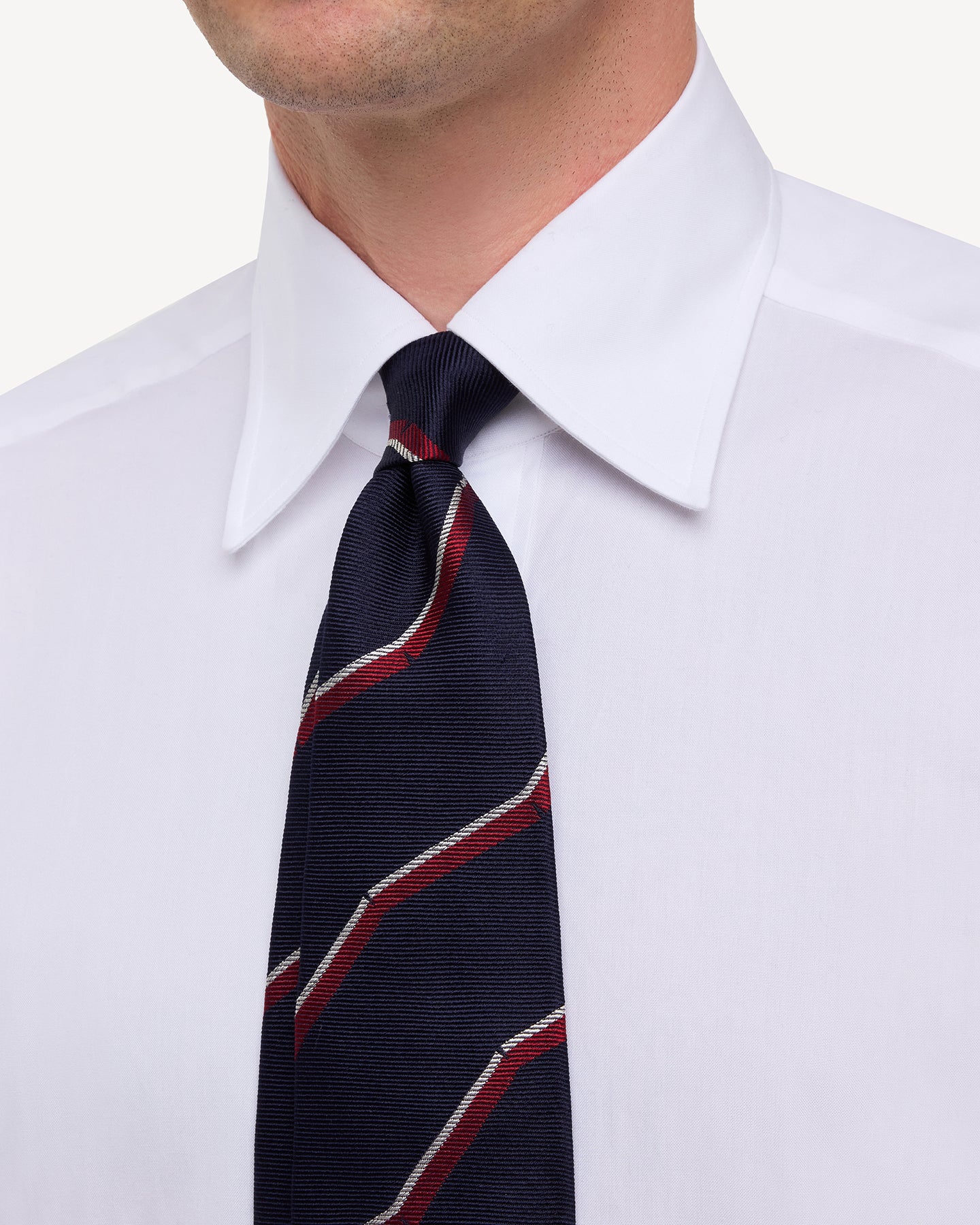 Man wearing white point collar shirt with Navy Red and White Broken Regimental Stripe Tie