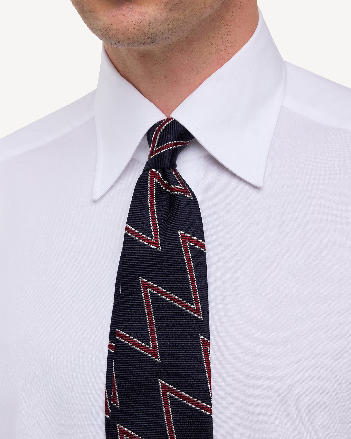 Man wearing white point collar shirt with Navy Red and White Royal Artillery Regimental Tie