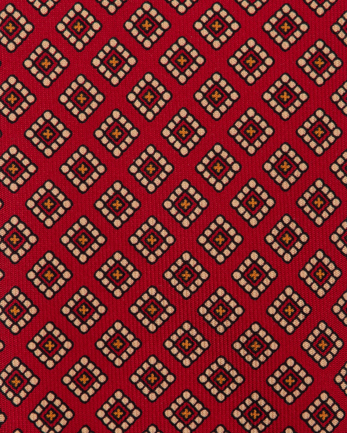 Red Ancient Madder tie with small medallion pattern in shades of cream, orange and black.