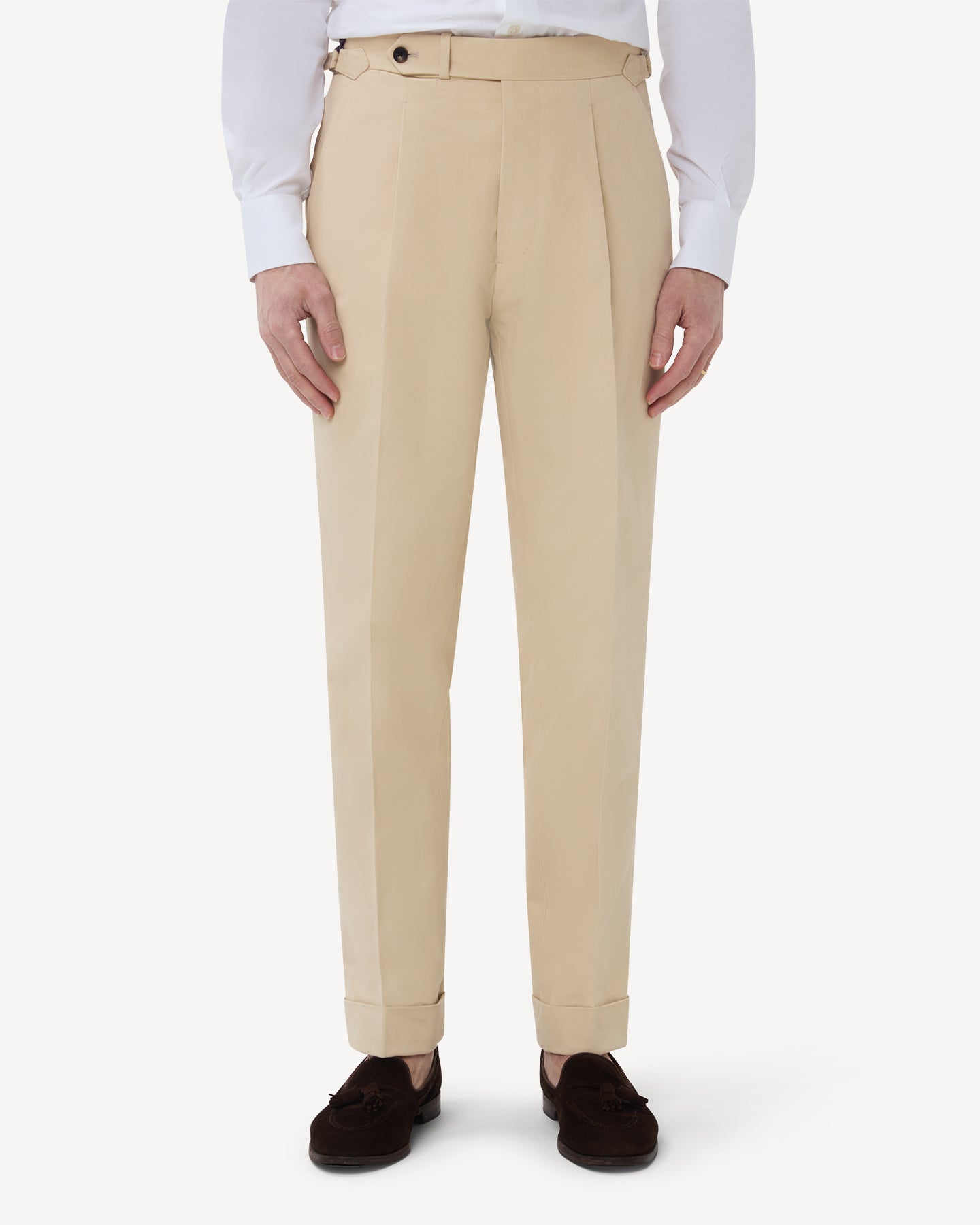 The front of cream cotton trousers with single pleats and side adjusters