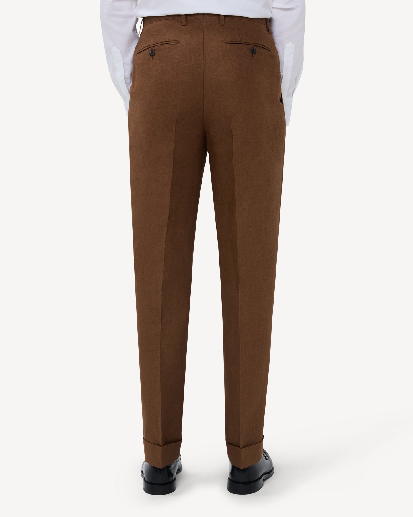 The back of dark tan linen trousers with double pleats and belt loops